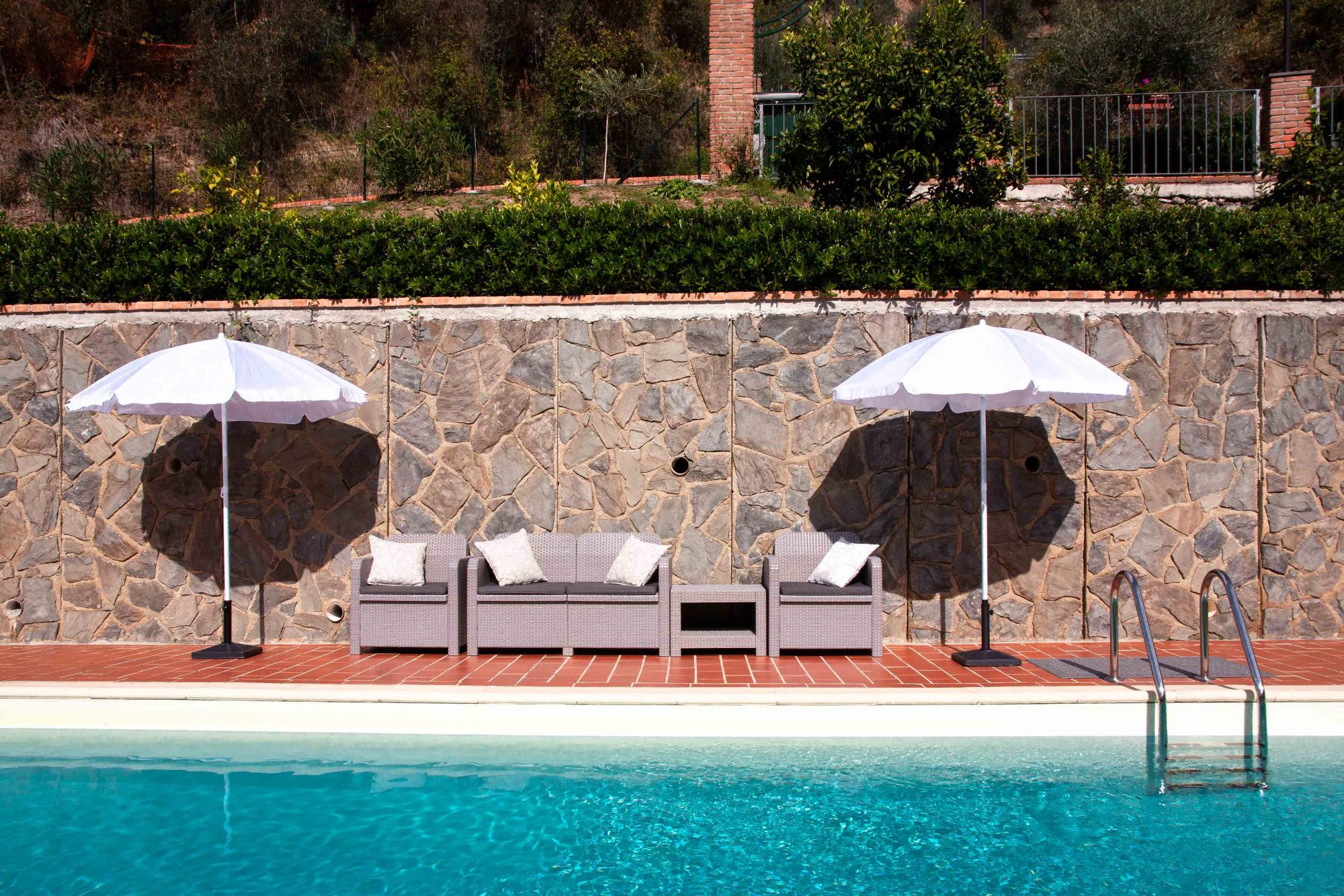 ombrelloni e poltroncine a bordo della piscina del bb vignola di levanto