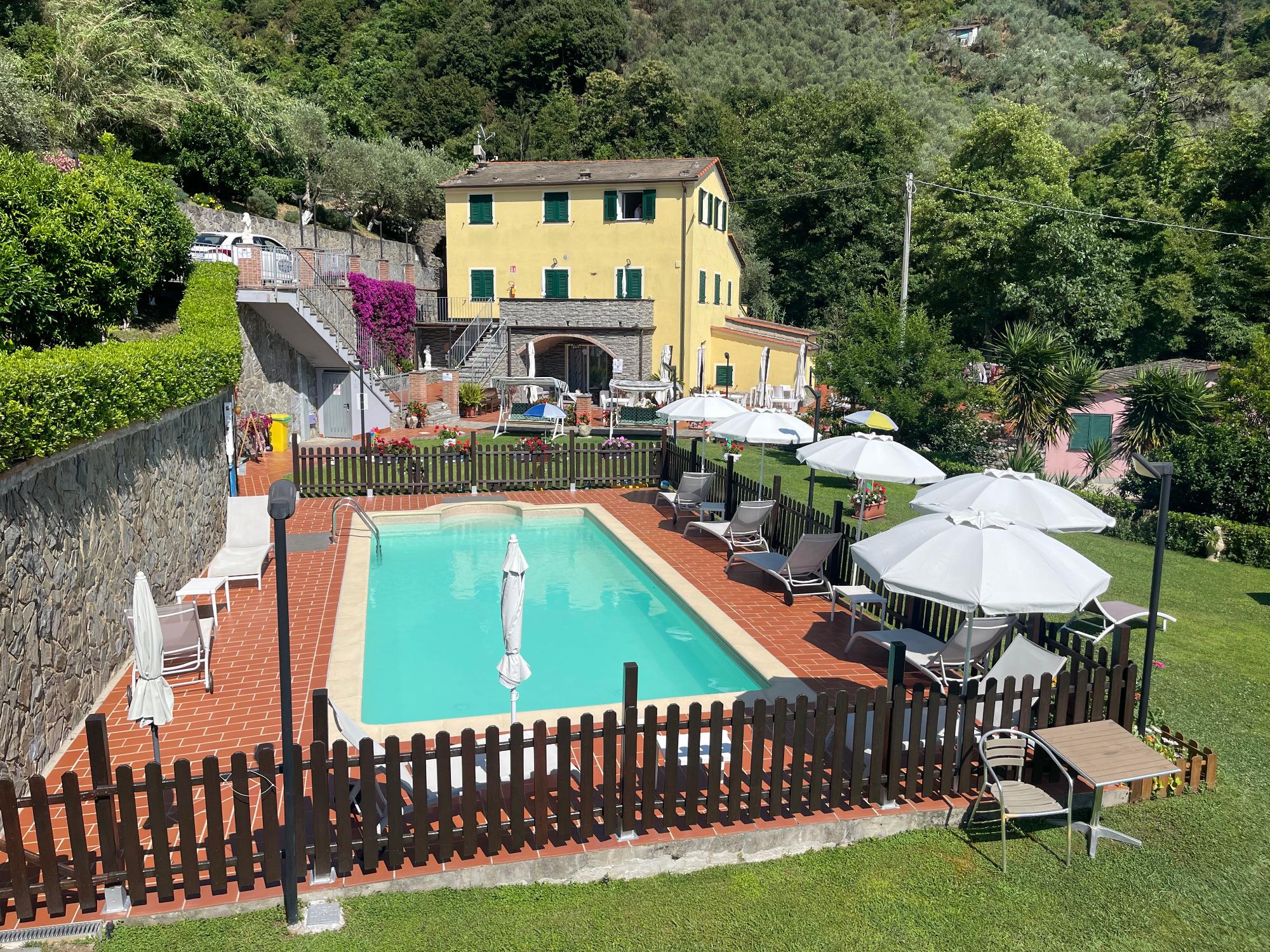 vista del giardino, della piscina e della facciata del bb vignola di levanto