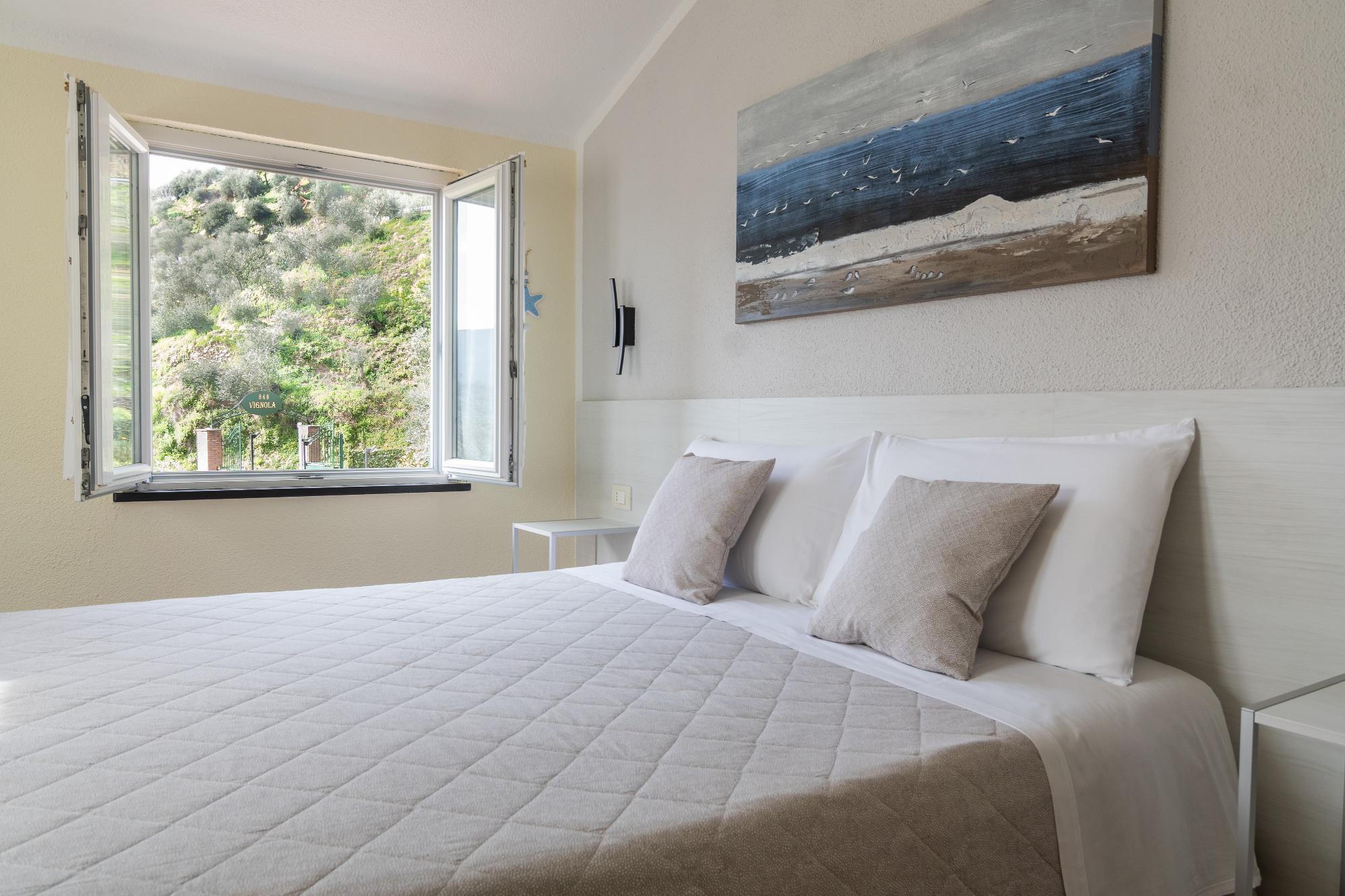 camera doppia bb vignola levanto, letto e vista da una delle finestre sulle colline circostanti