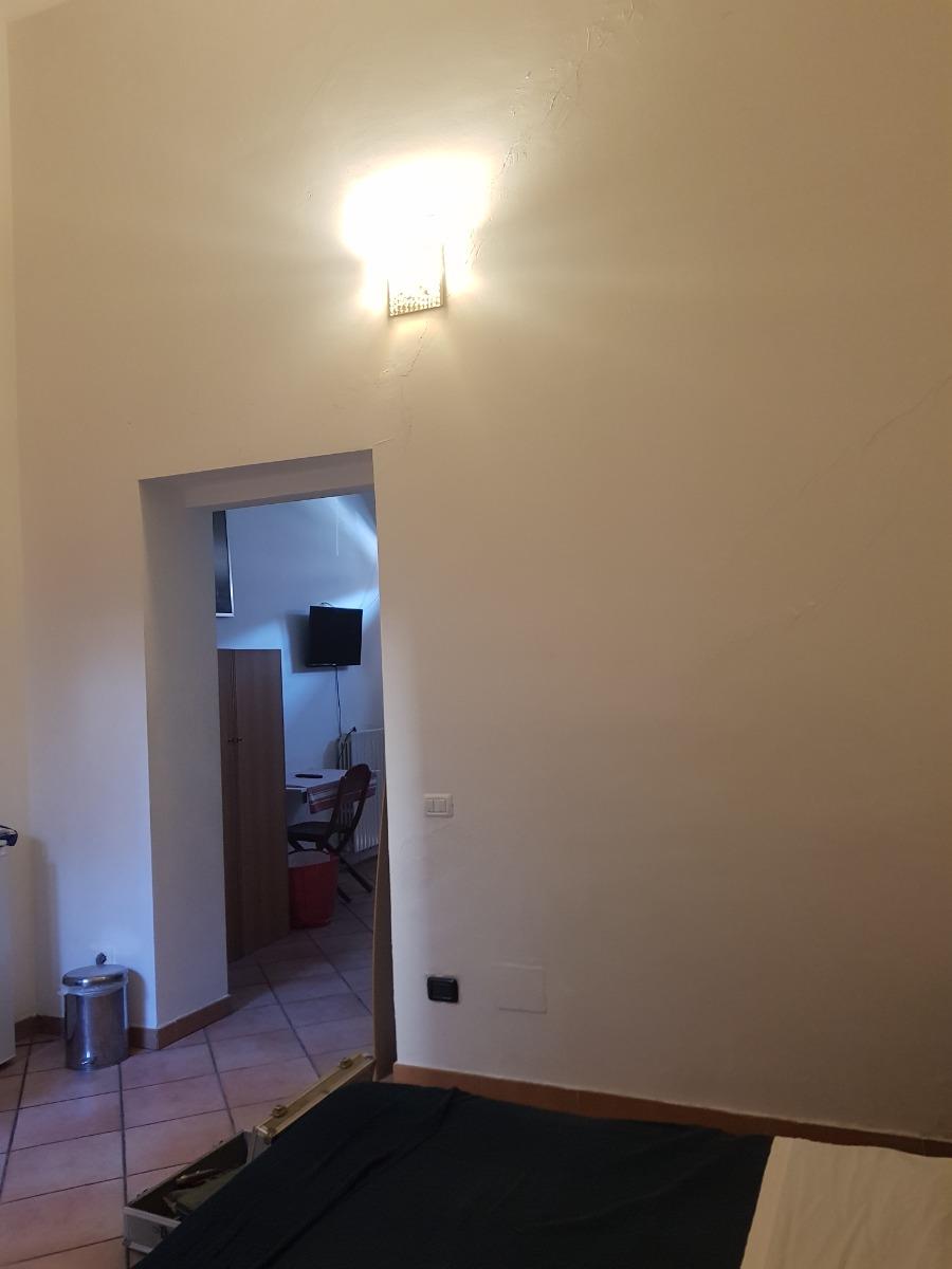 camera da letto dove si intravvede il soggiorno col divano letto