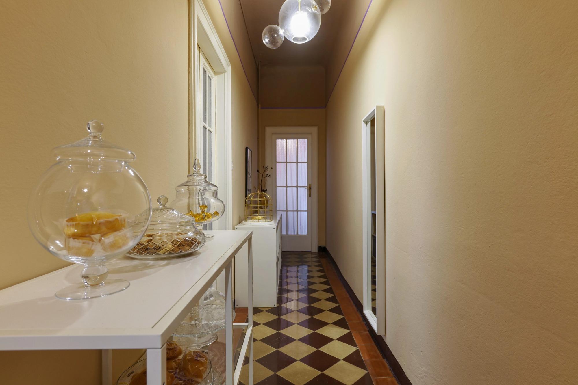 Corridoio di House of Frames Milano con pavimento originale in cementine e una selezione di dolcetti per gli ospiti
