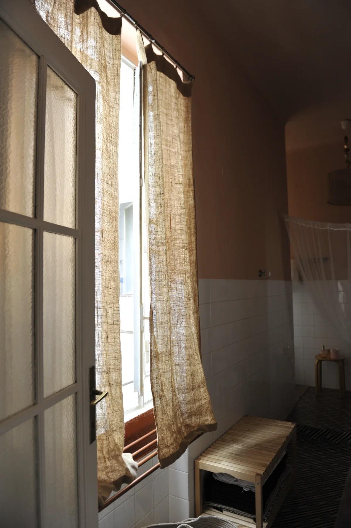 Bagno condiviso di House of Frames Milano con luce naturale e tende in lino