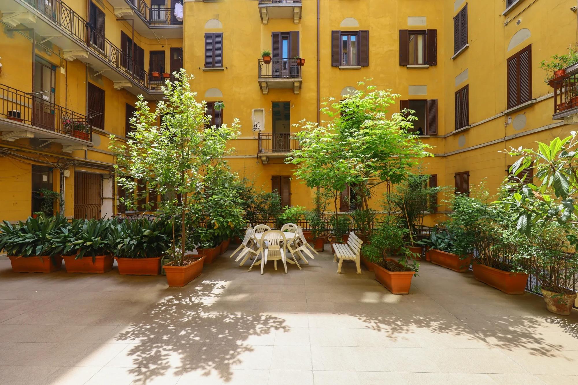 Cortile interno verde di House of Frames Milano in una tipica casa di ringhiera milanese