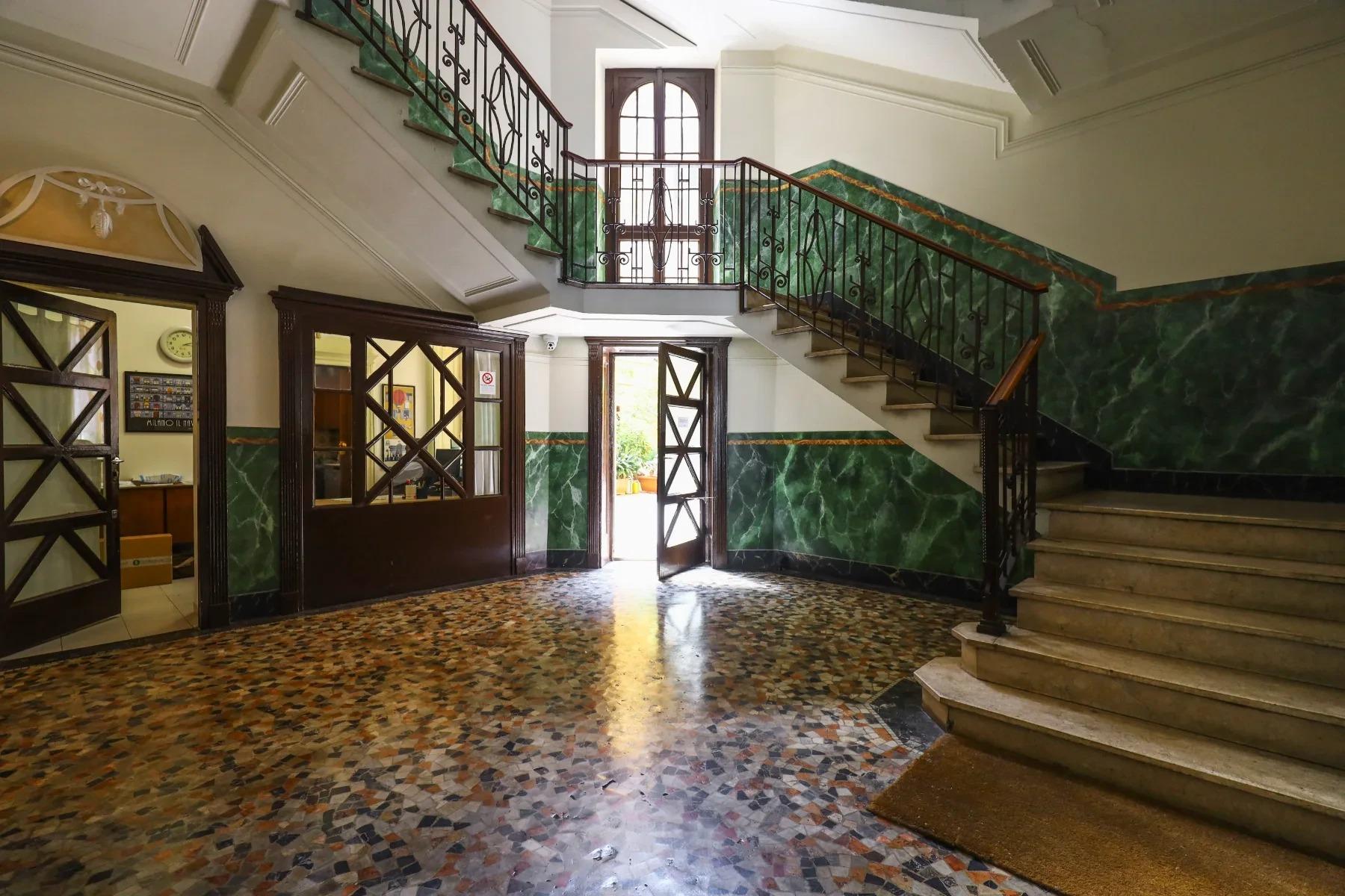ngresso Art Déco del palazzo di House of Frames Milano con scala e rivestimenti in marmo verde