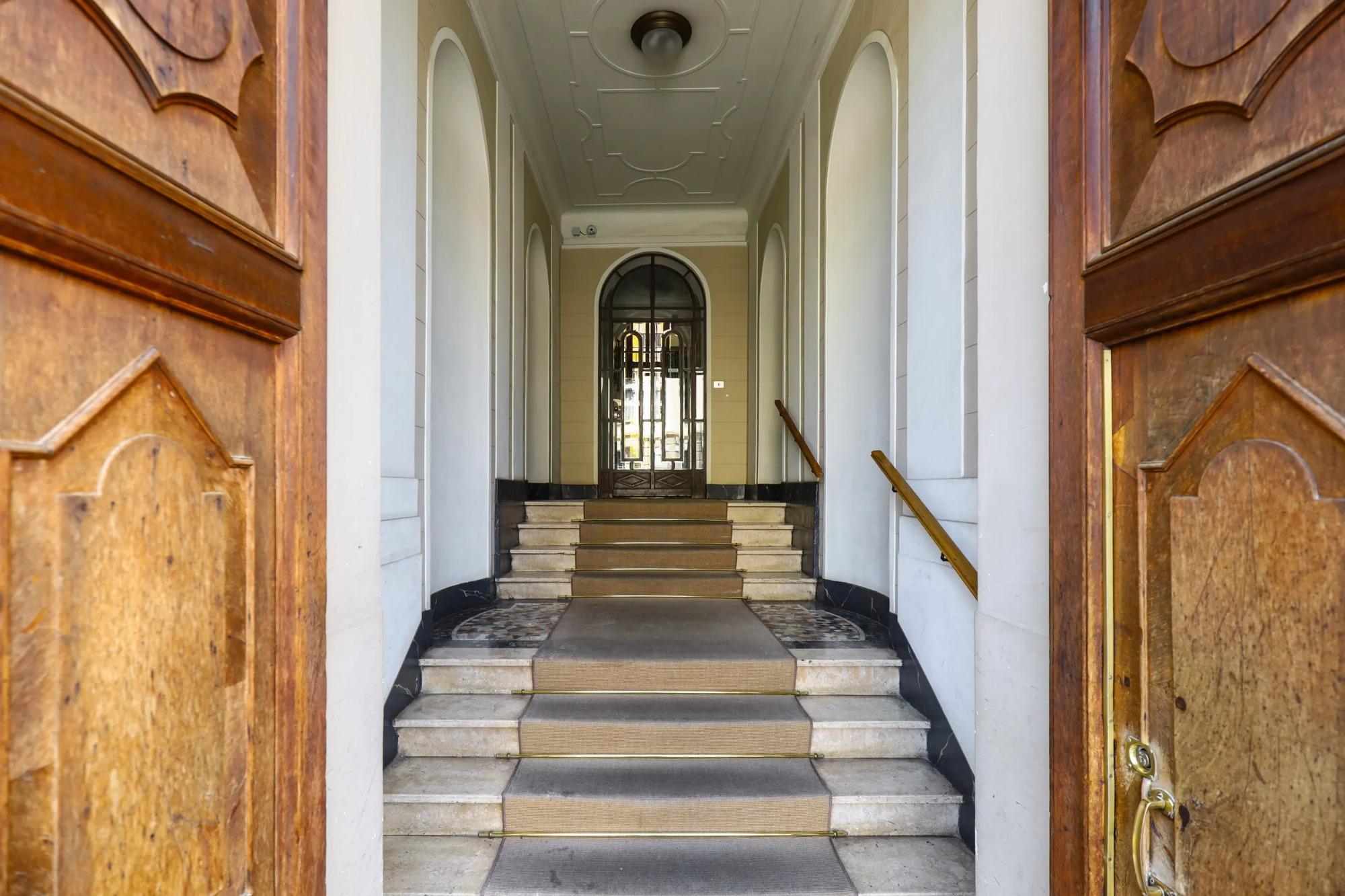 Ingresso dello storico palazzo milanese di House of Frames con portone originale in legno