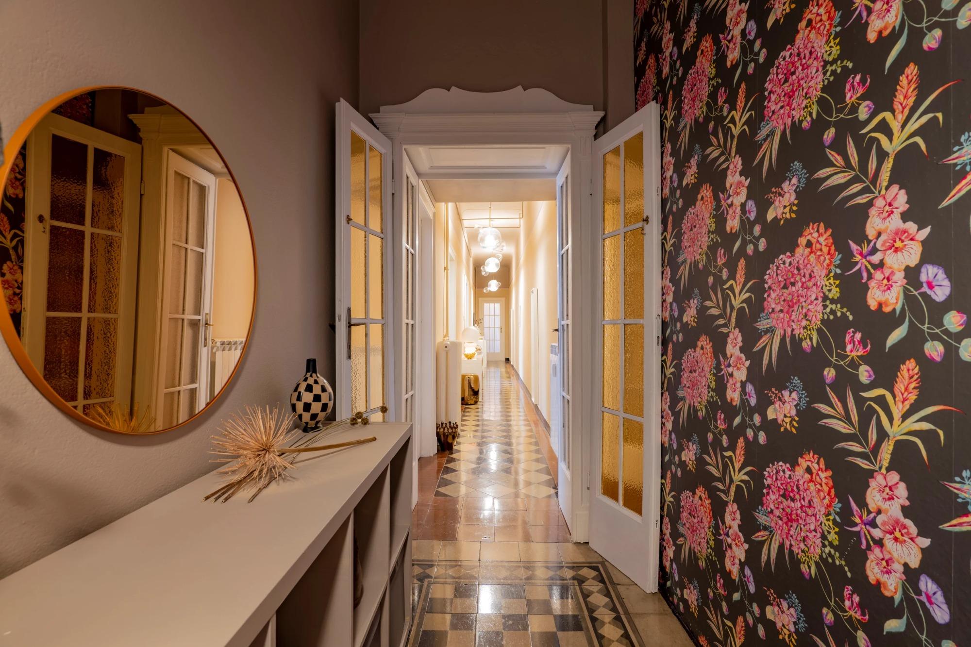 Ingresso con carta da parati floreale anni Settanta, specchio tondo e sospensione Bolle di Giopato & Coombes, House of Frames Milano