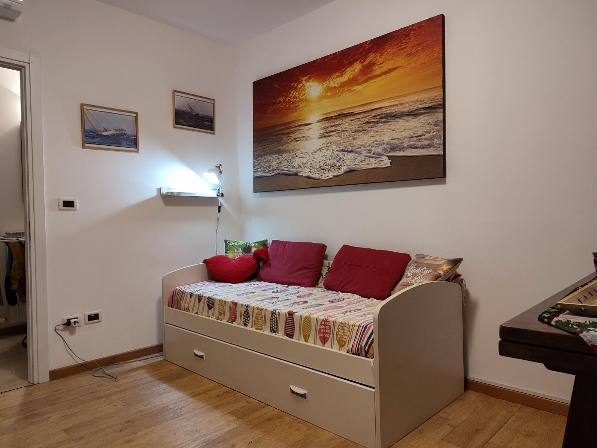 Stanza con angolo cucina e divano con letto estraibile