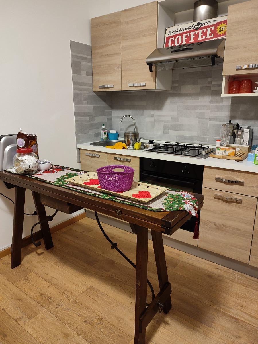 Angolo cucina con forno elettrico, frigorifero, fornetto a microonde, tostapane e fornelli