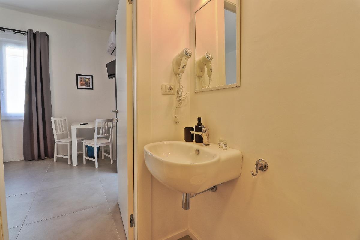 La camera, con bagno privato, è attrezzata con letto matrimoniale, aria condizionata, poggia valige, scrivania, TV, asciugacapelli.