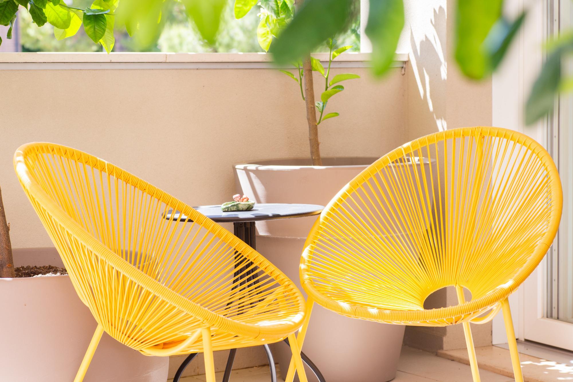 Coppia di poltrone di design gialle con tavolino sulla terrazza soleggiata del B&B Fontanella 32.