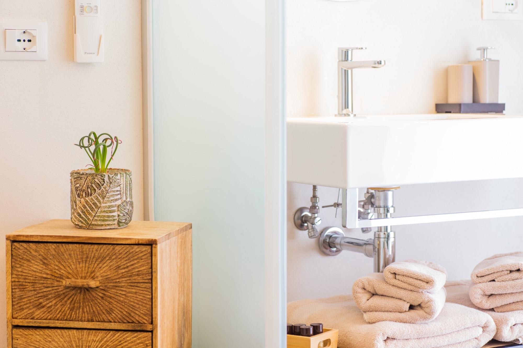 Dettaglio del bagno privato della Camera Sabbia del B&B Fontanella 32 a Porto Sant'Elpidio, con asciugamani color tortora e arredi moderni in legno