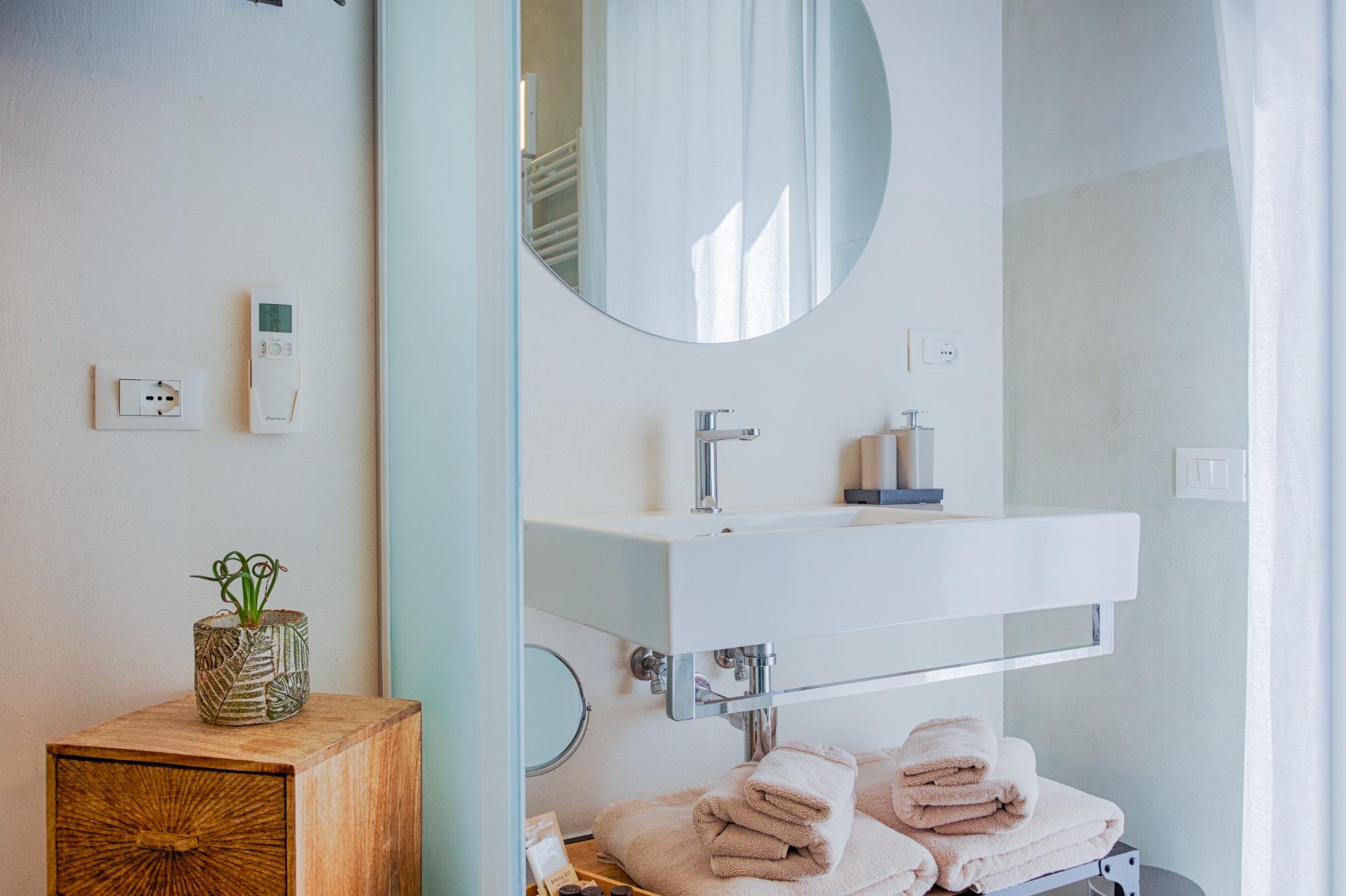 Moderno bagno privato della Camera Verde con rivestimento doccia verde oliva, sanitari sospesi e phon a muro