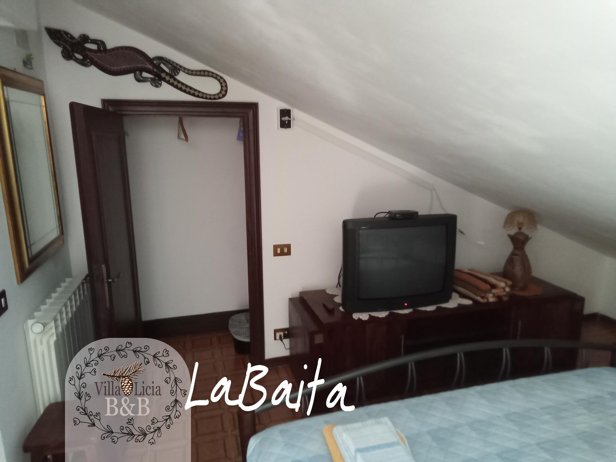 La camera Baita di Villa Licia con atmosfera intima e rilassante.