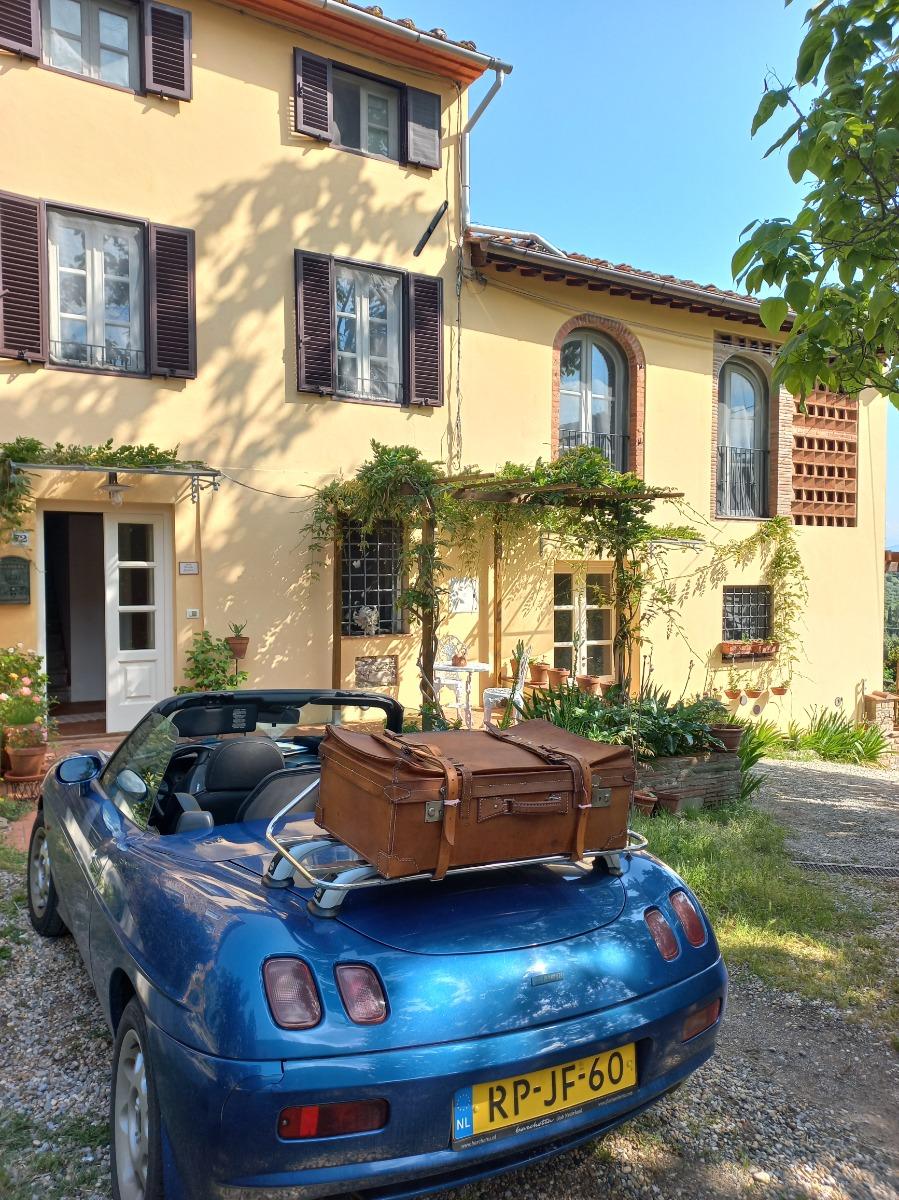 Facciata con parcheggio di fronte porta entrata e patio area fumatori.