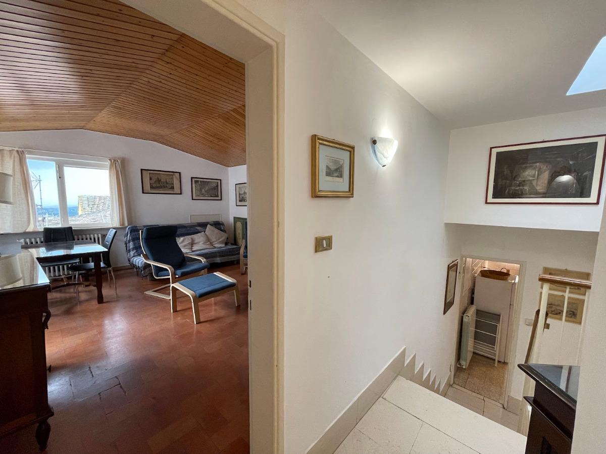 soggiorno e scale che scendono in cucina