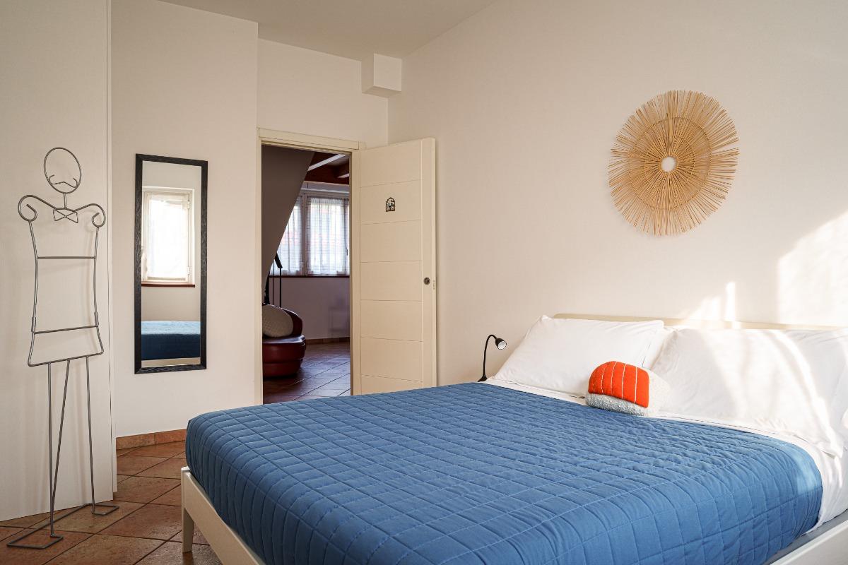 Camera da letto finestrata con letto matrimoniale e armadio