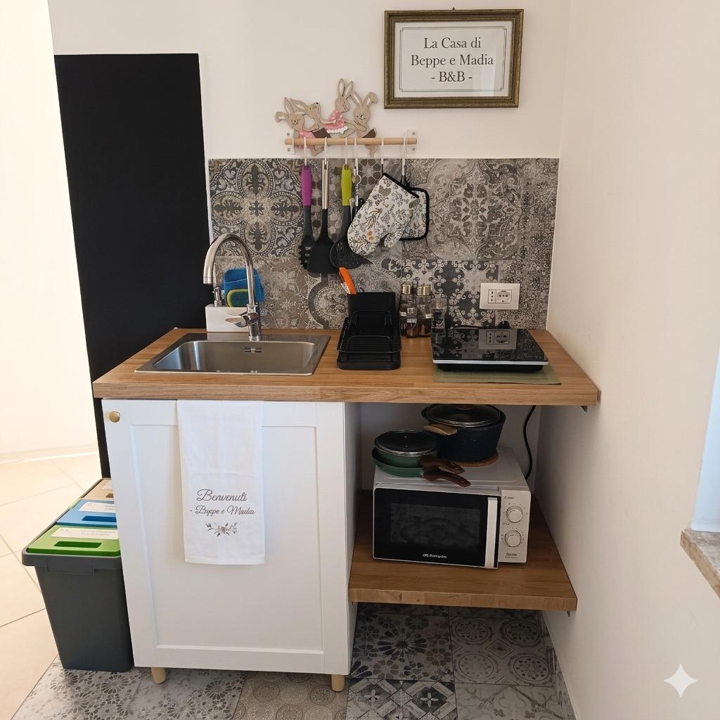 Angolo Cottura. Funzionalità e stile a La Casa di Beppe e Madia a Bisceglie. Cucina attrezzata con microonde e piastra per il tuo soggiorno in Puglia.