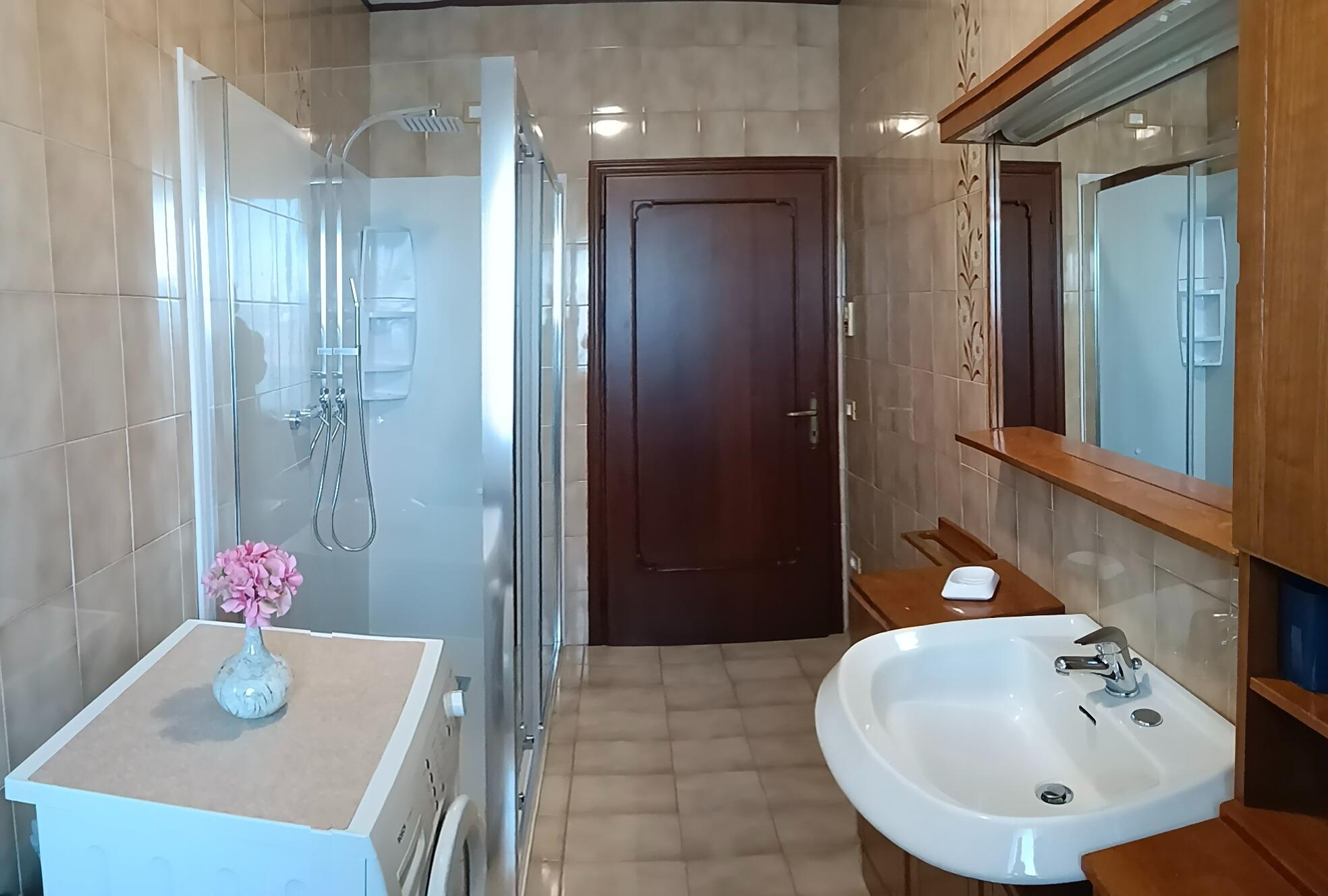 Bagno con doccia e lavatrice