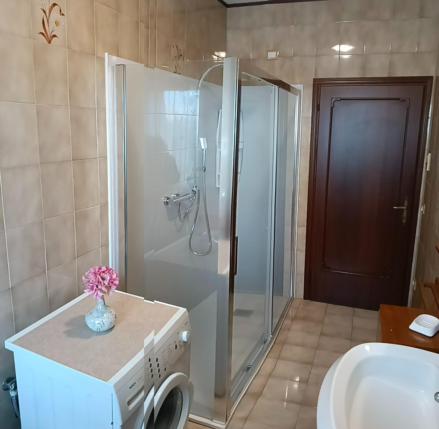 Bagno con doccia e lavatrice