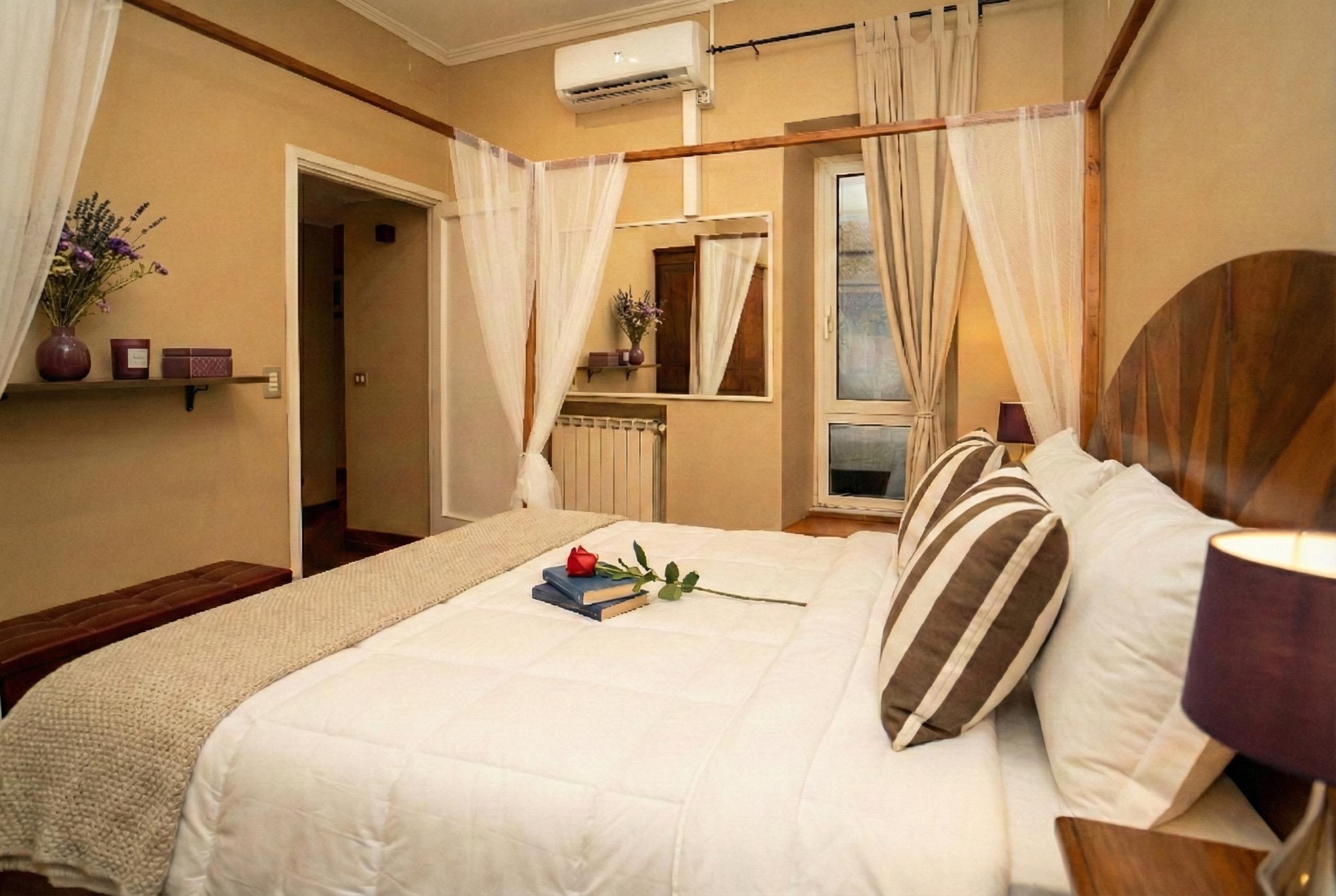 Camera da letto 1. Armadio in legno. Aria condizionata. Deposito bagagli, con spazio in abbondanza. Finestra su patio verdeggiante