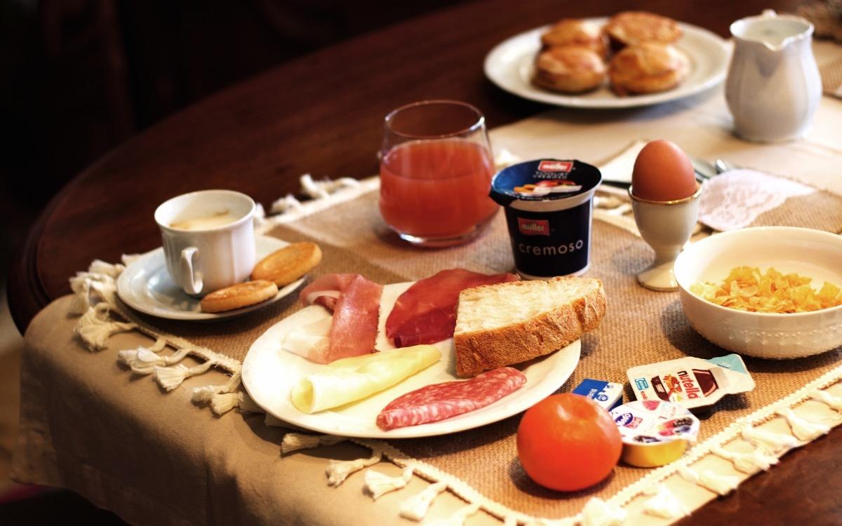 Table set with sweet and savory breakfast foods and beverages