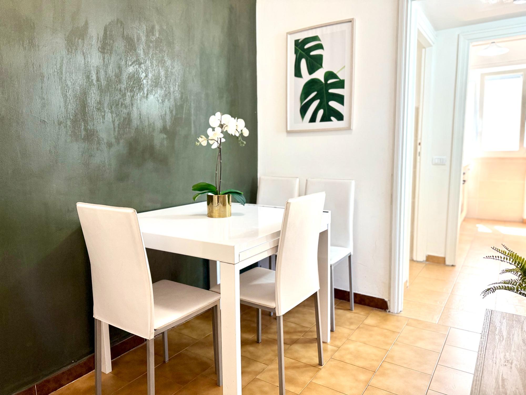 Una zona pranzo luminosa e accogliente con un tavolo moderno e posti a sedere per quattro persone, perfetta per gustare i pasti o lavorare in un ambie