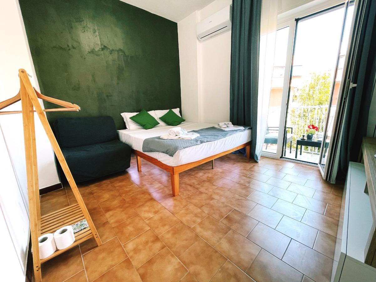 Camera da letto luminosa e raffinata con un comodo letto king-size, aria condizionata, una zona salotto accogliente e accesso diretto al balcone, perf