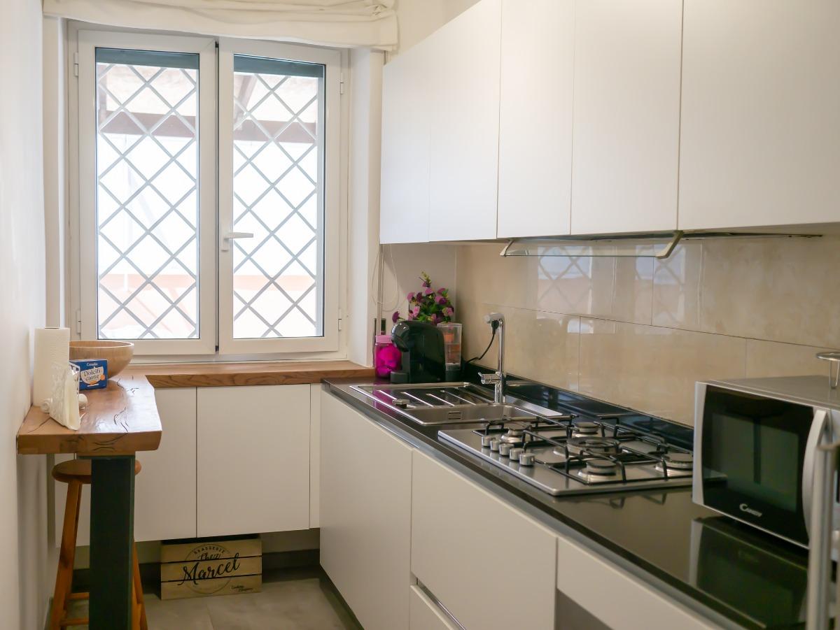 Cucina completa di: piano cottura, forno, microonde, macchina del caffè, lavastoviglie e frigorifero.
