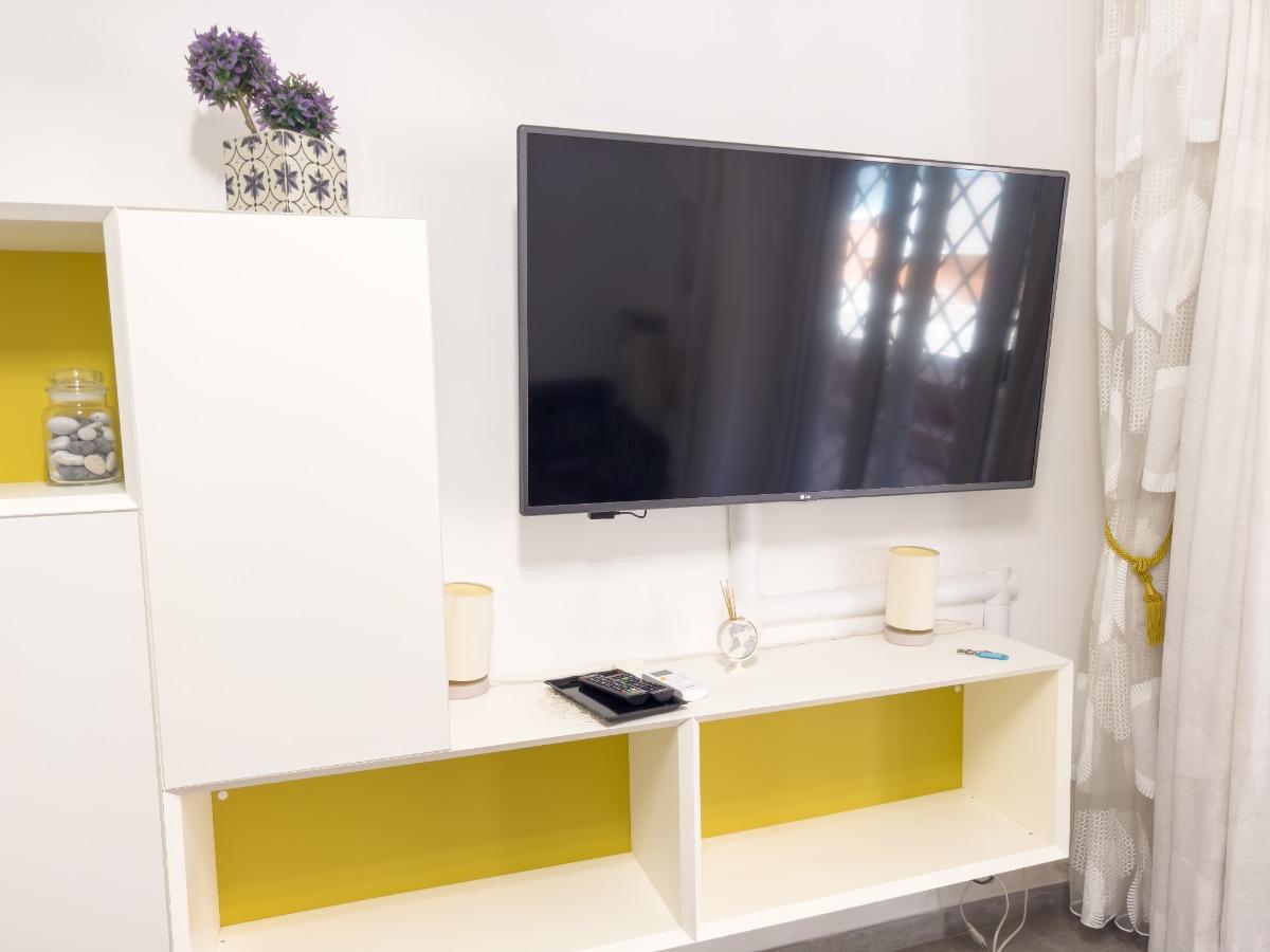 Soggiorno con divano letto matrimoniale, aria condizionata, tavolo da pranzo, tv a schermo piatto, accesso al giardino.