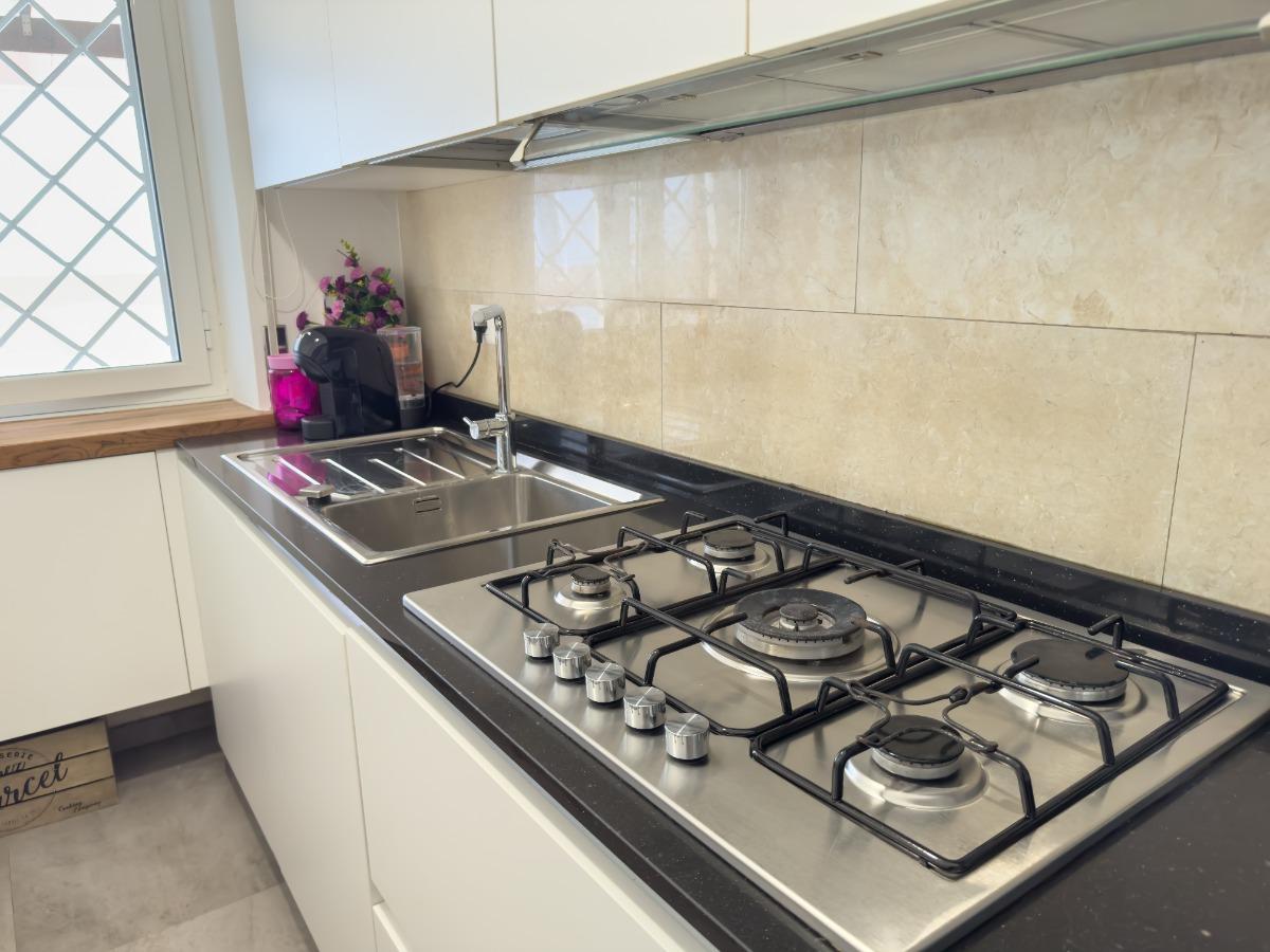 Cucina completa di: piano cottura, forno, microonde, macchina del caffè, lavastoviglie e frigorifero.