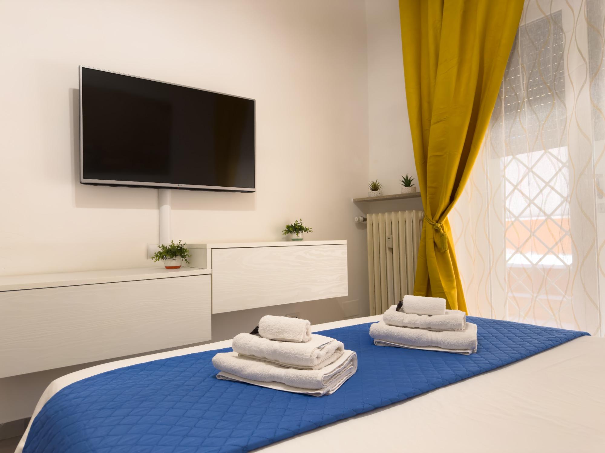 Camera da letto con aria condizionata, tv, armadio e accesso al giardino.