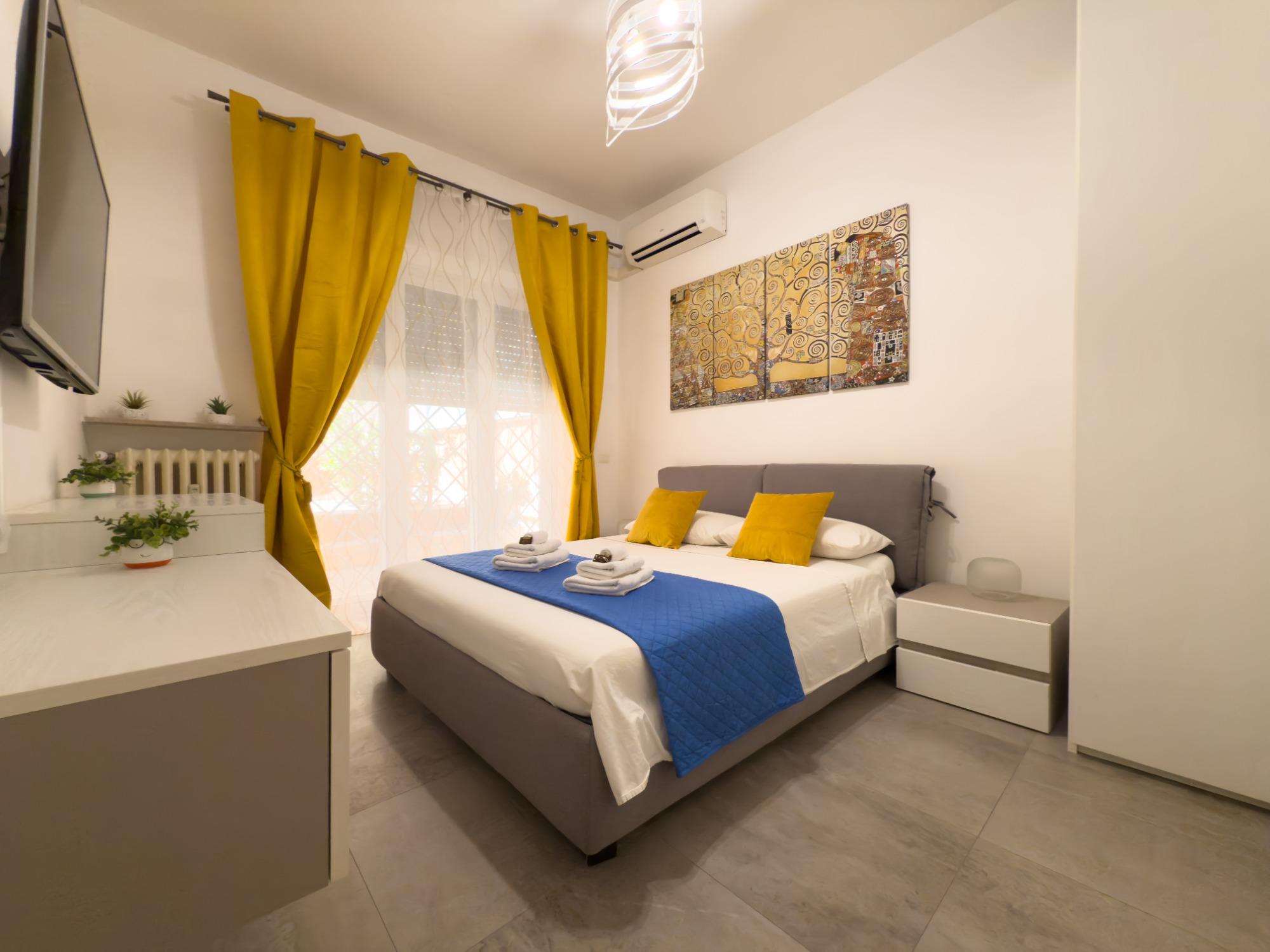 Camera da letto con aria condizionata, tv, armadio e accesso al giardino.