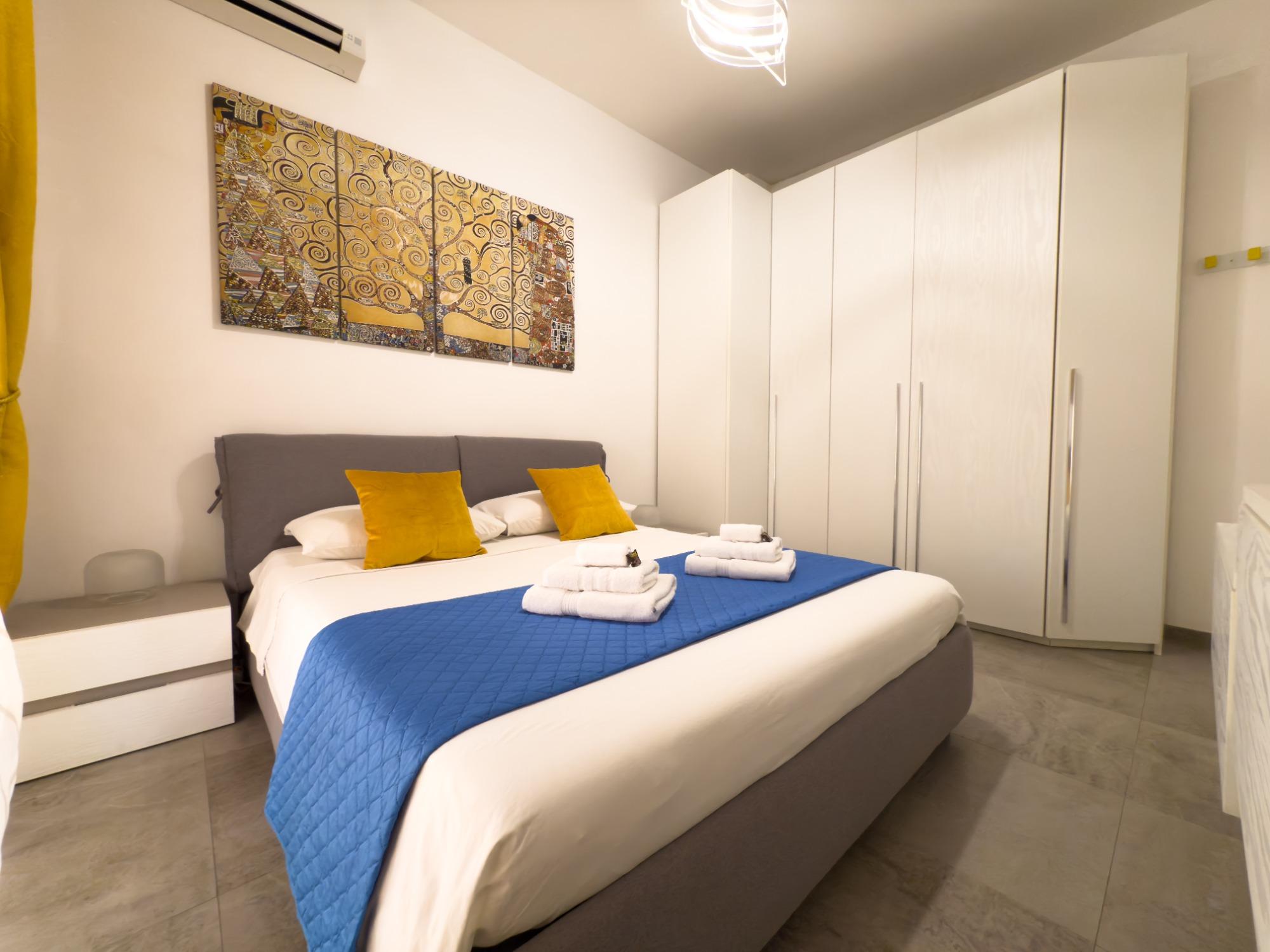 Camera da letto con aria condizionata, tv, armadio e accesso al giardino.