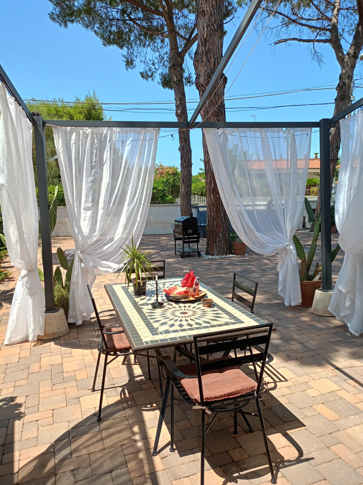 gazebo esterno con tende su giardino