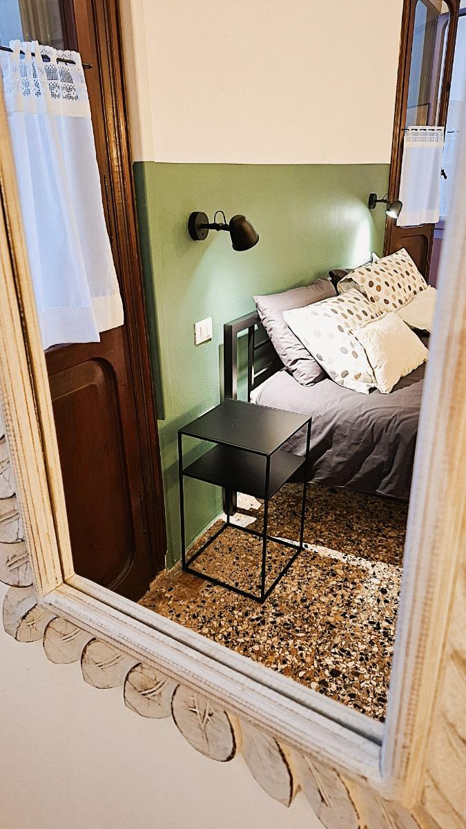 particolare letto con comodini e luci da lettura