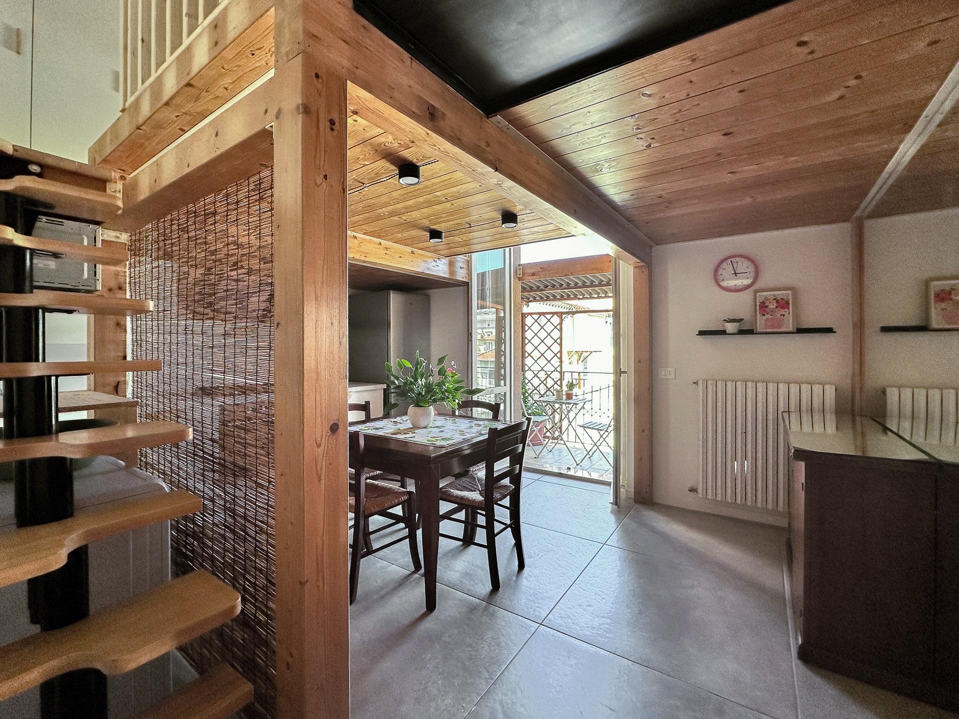 Cucina e sala da pranzo con accesso al terrazzino coperto e scale per la camera soppalcata