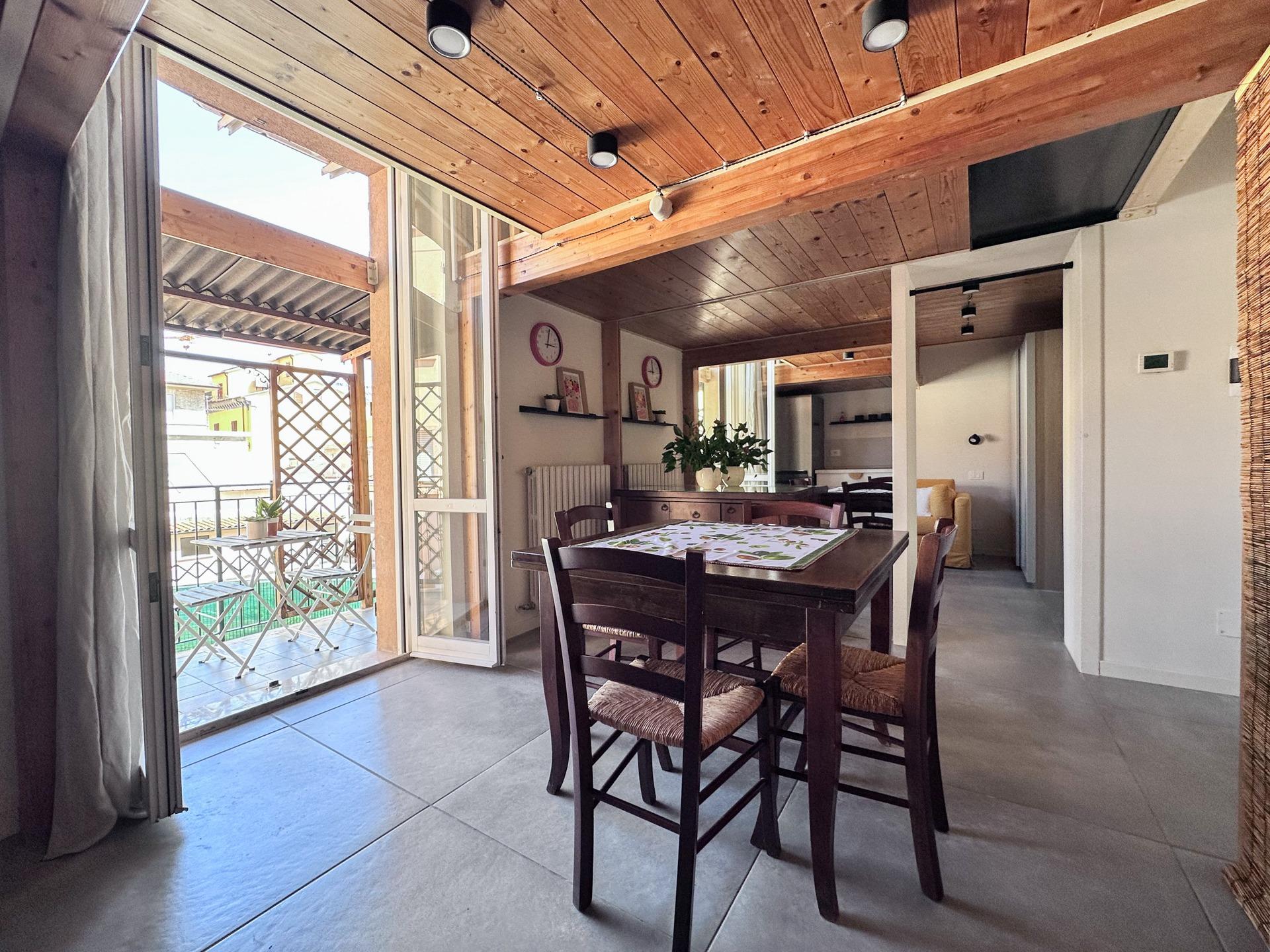 cucina e sala da pranzo con accesso al terrazzino coperto