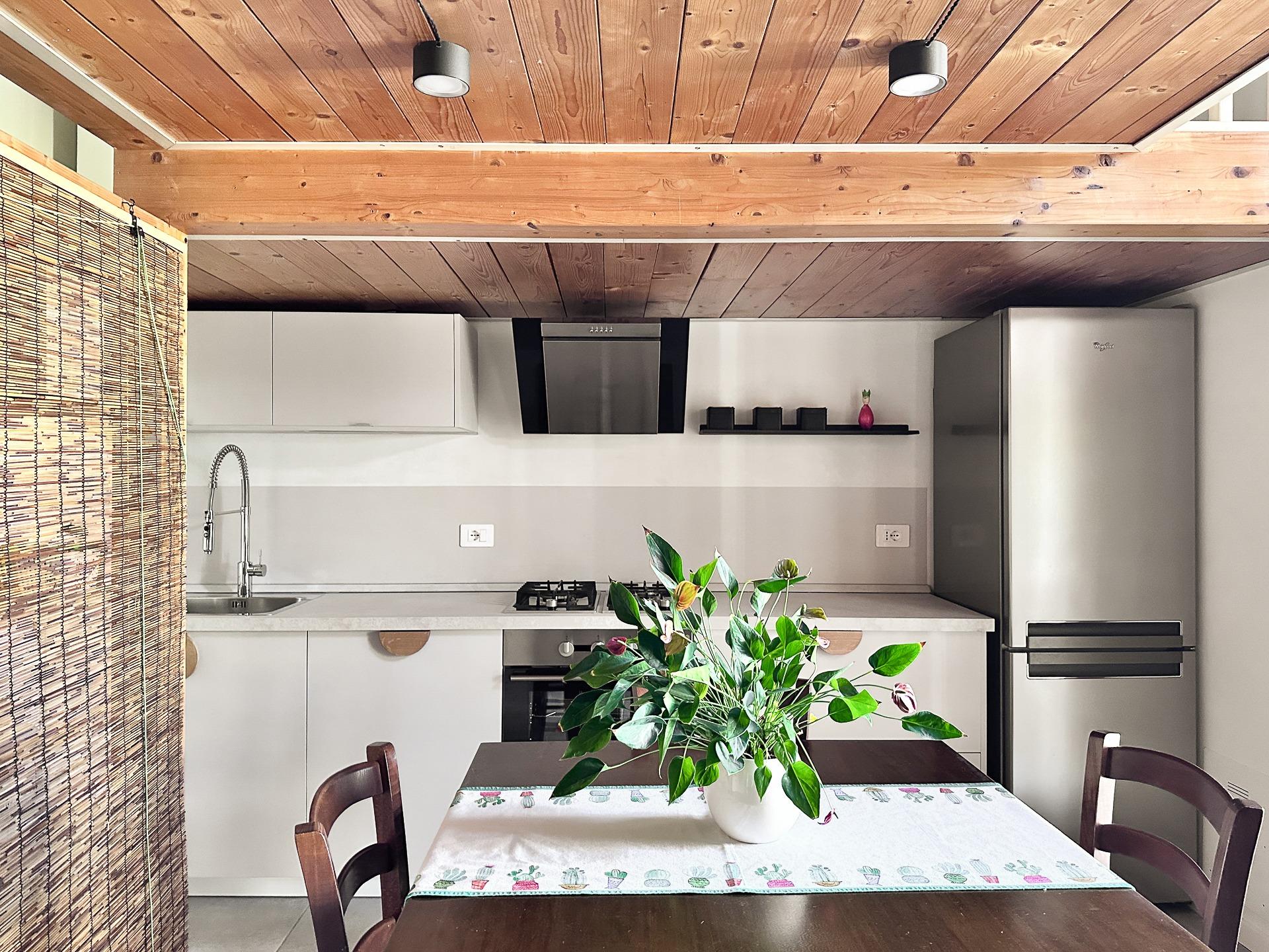 cucina e sala da pranzo con accesso al terrazzino coperto