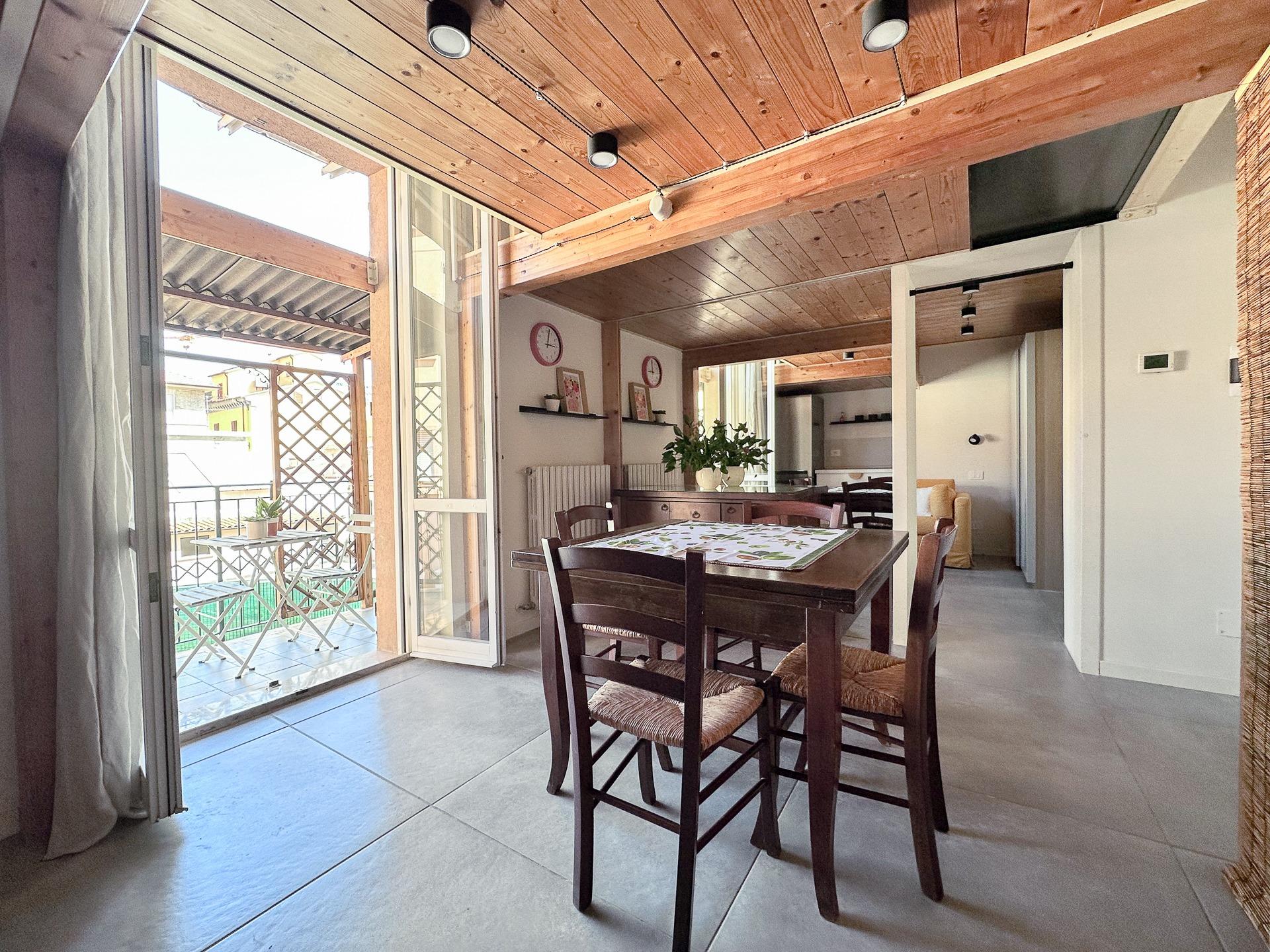 cucina e sala da pranzo con accesso al terrazzino coperto