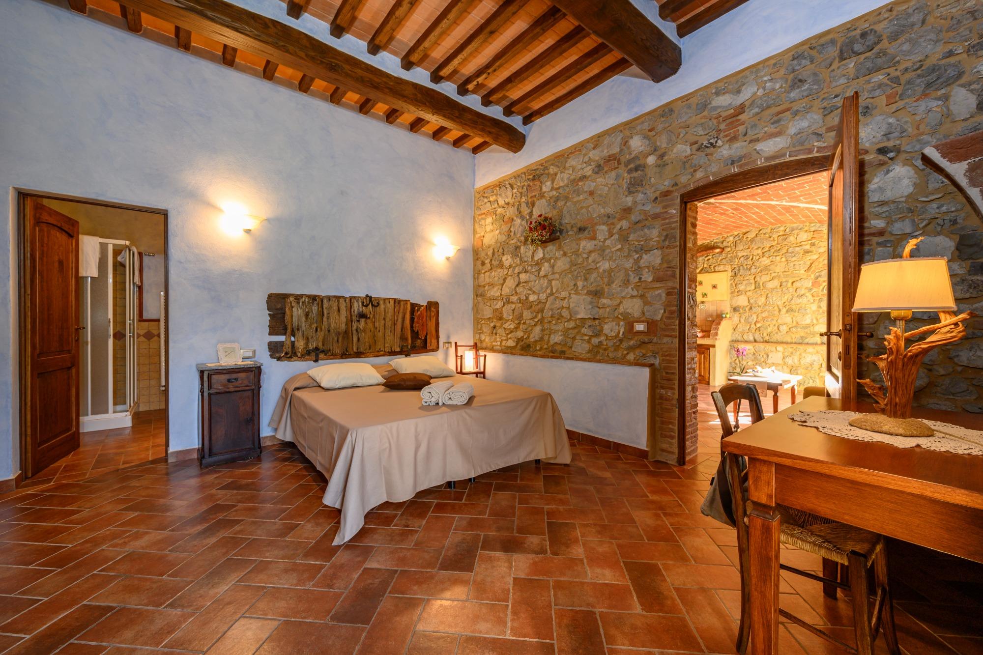 Camera con pareti in pietra e travi a vista