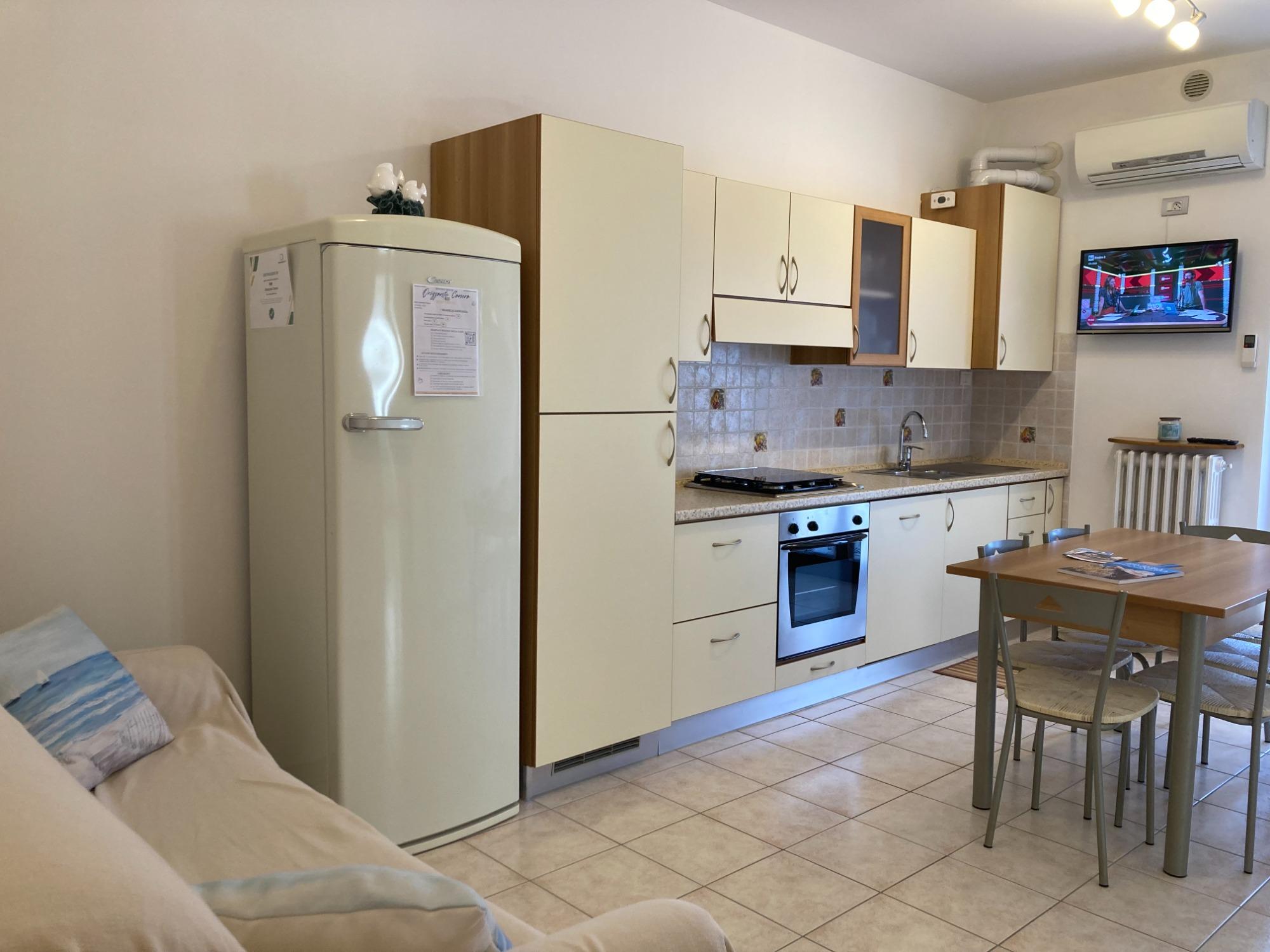 cucina che affaccia sul balcone, completamente arredata.