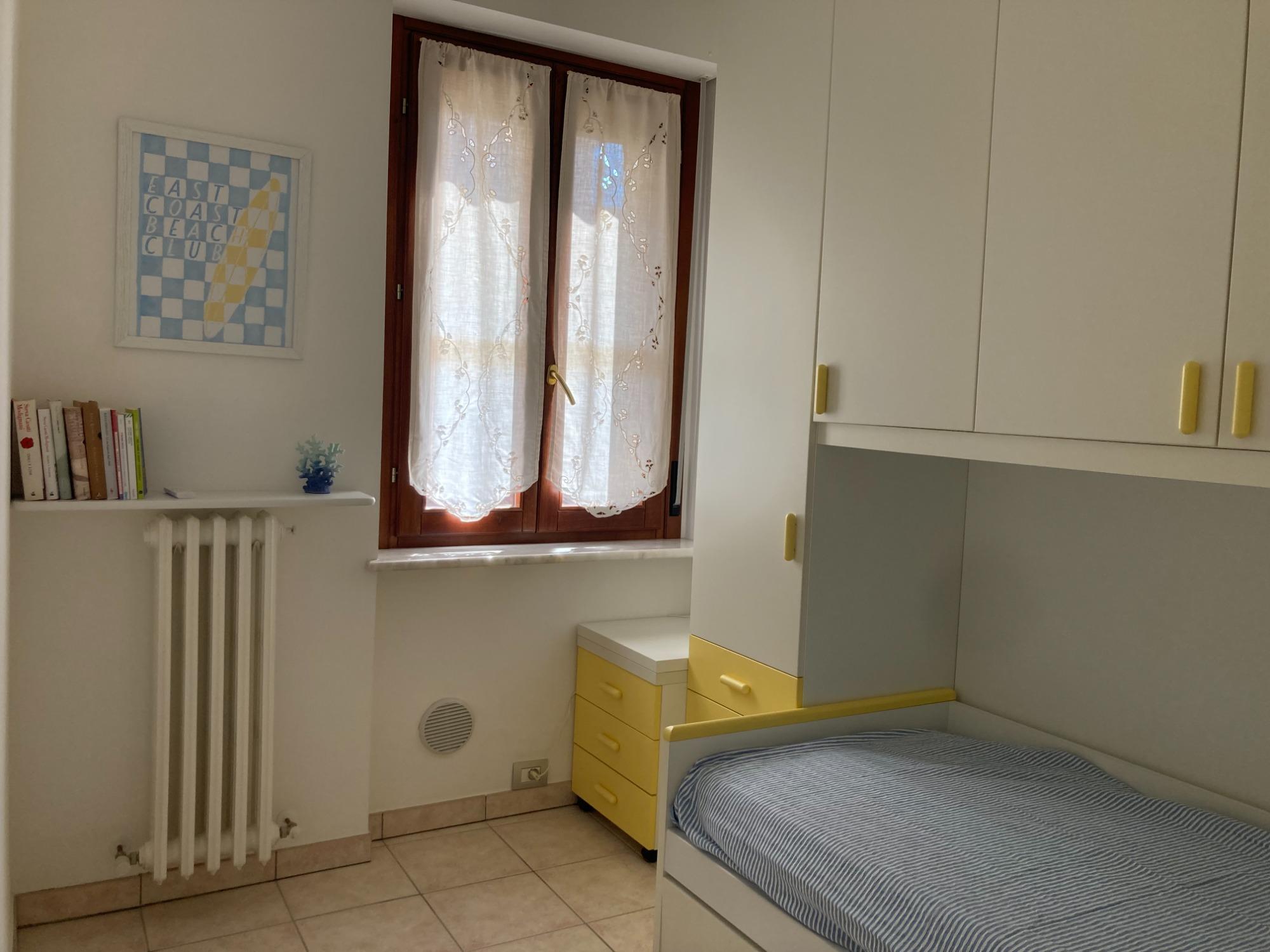 cameretta con secondo letto estraibile, televisore e ampia armadiatura