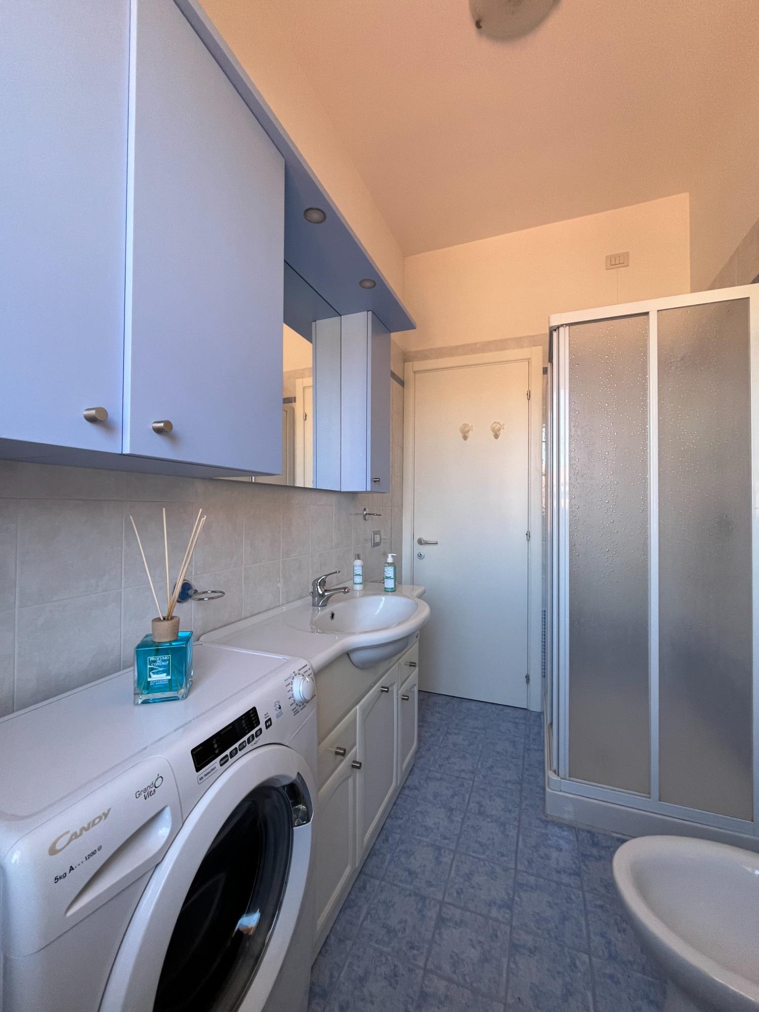 bagno arredato con lavatrice e finestra