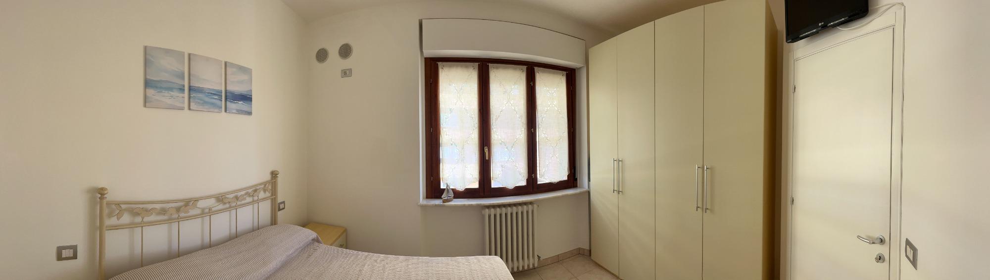 panoramica della camera con televisore e armadiatura con cassaforte