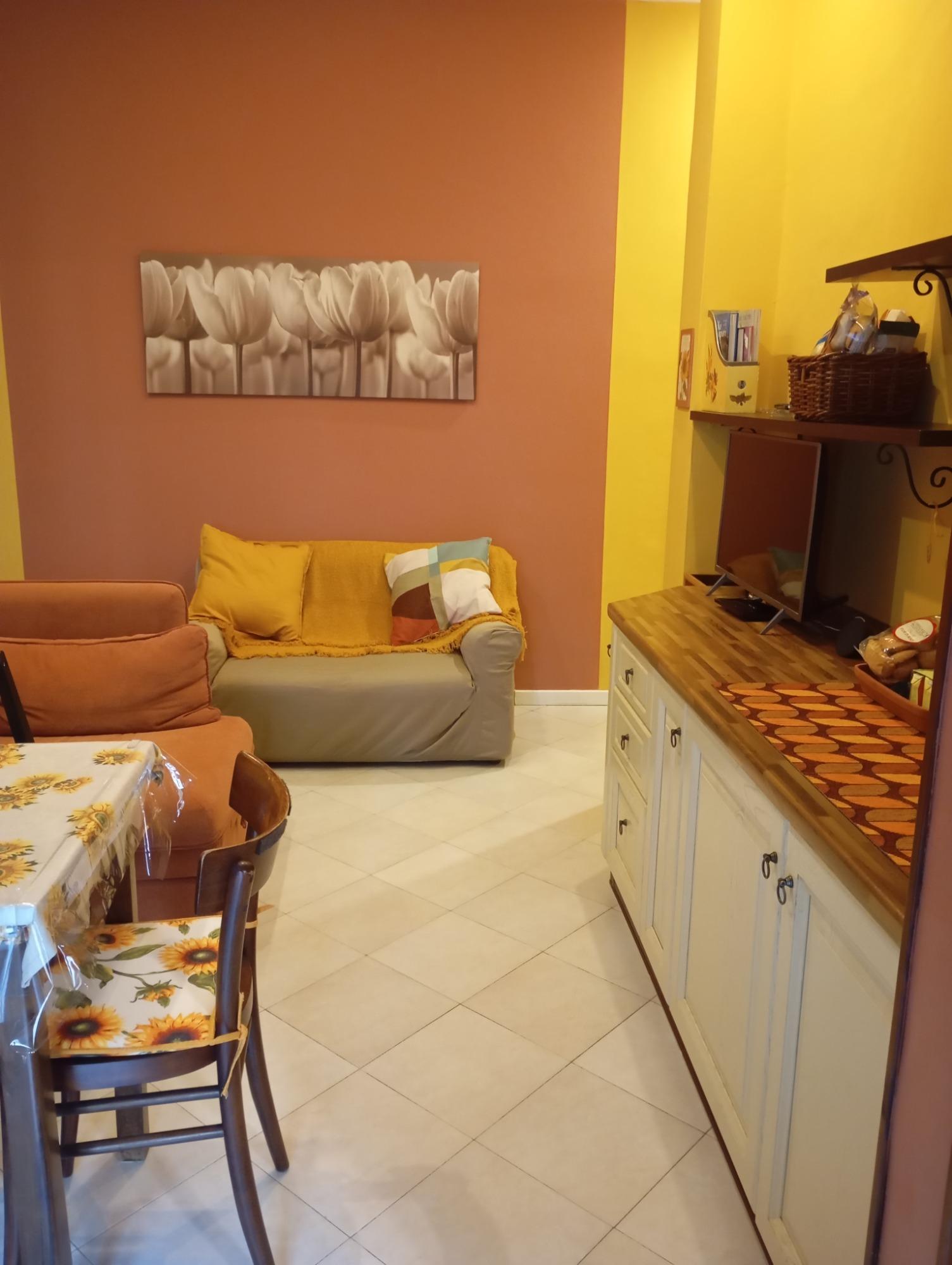 Un salotto dal fascino autentico: due divani accoglienti (uno diventa letto singolo), smart TV e il tavolo della nonna con sedie d' epoca