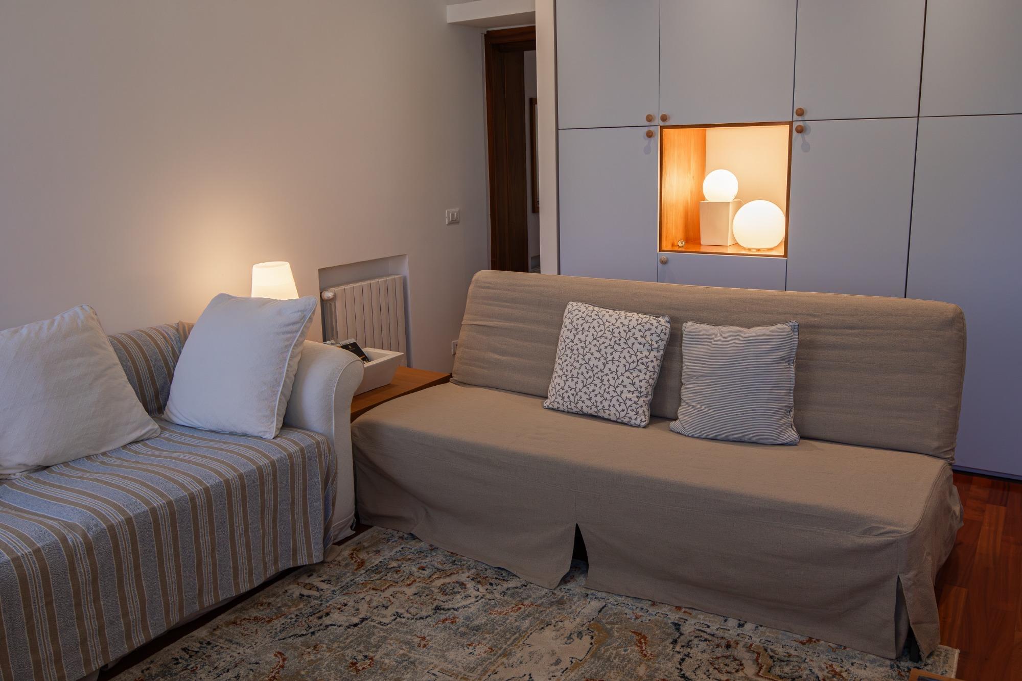 Divano letto per due persone e armadio sullo sfondo