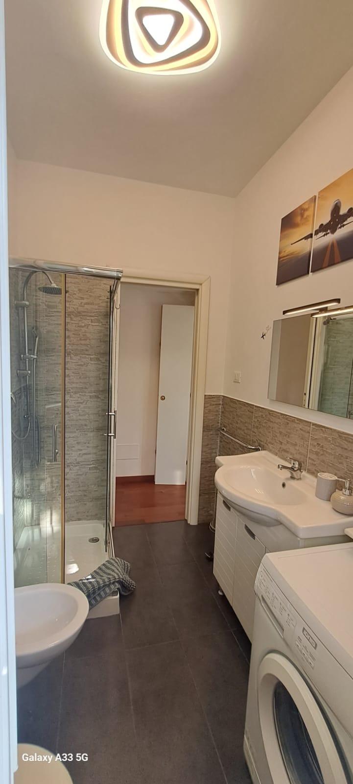 Bagno con doccia e lavatrice