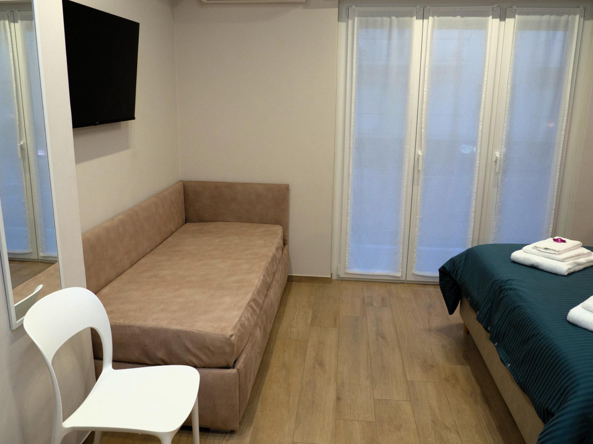 Overview of single beds and balcony in Sogno room