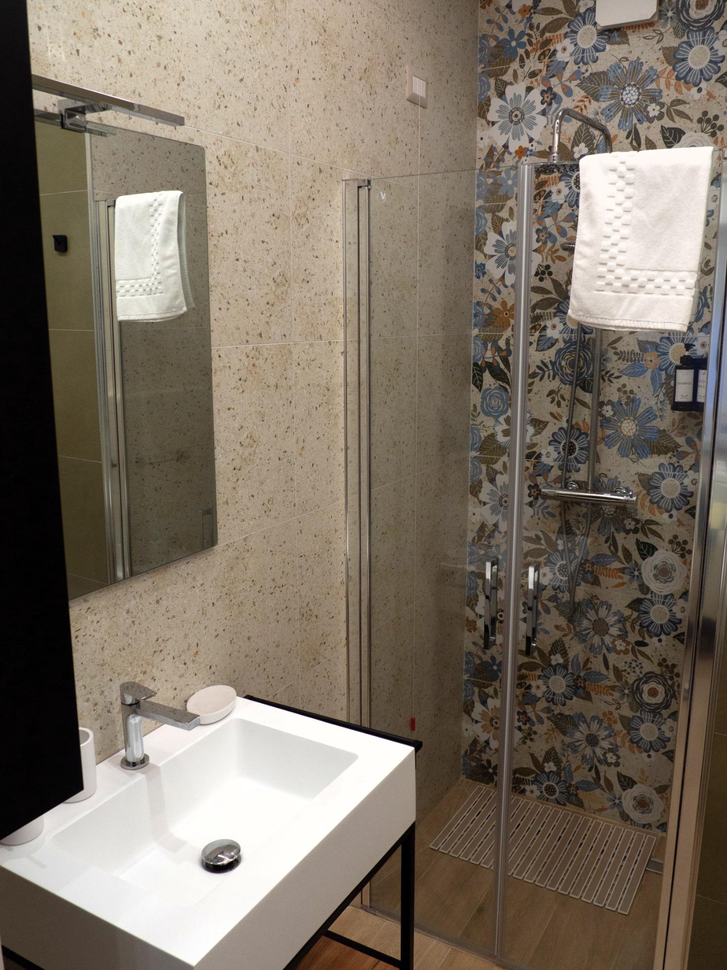 Bagno privato con doccia, lavandino e specchio nella camera Poesia