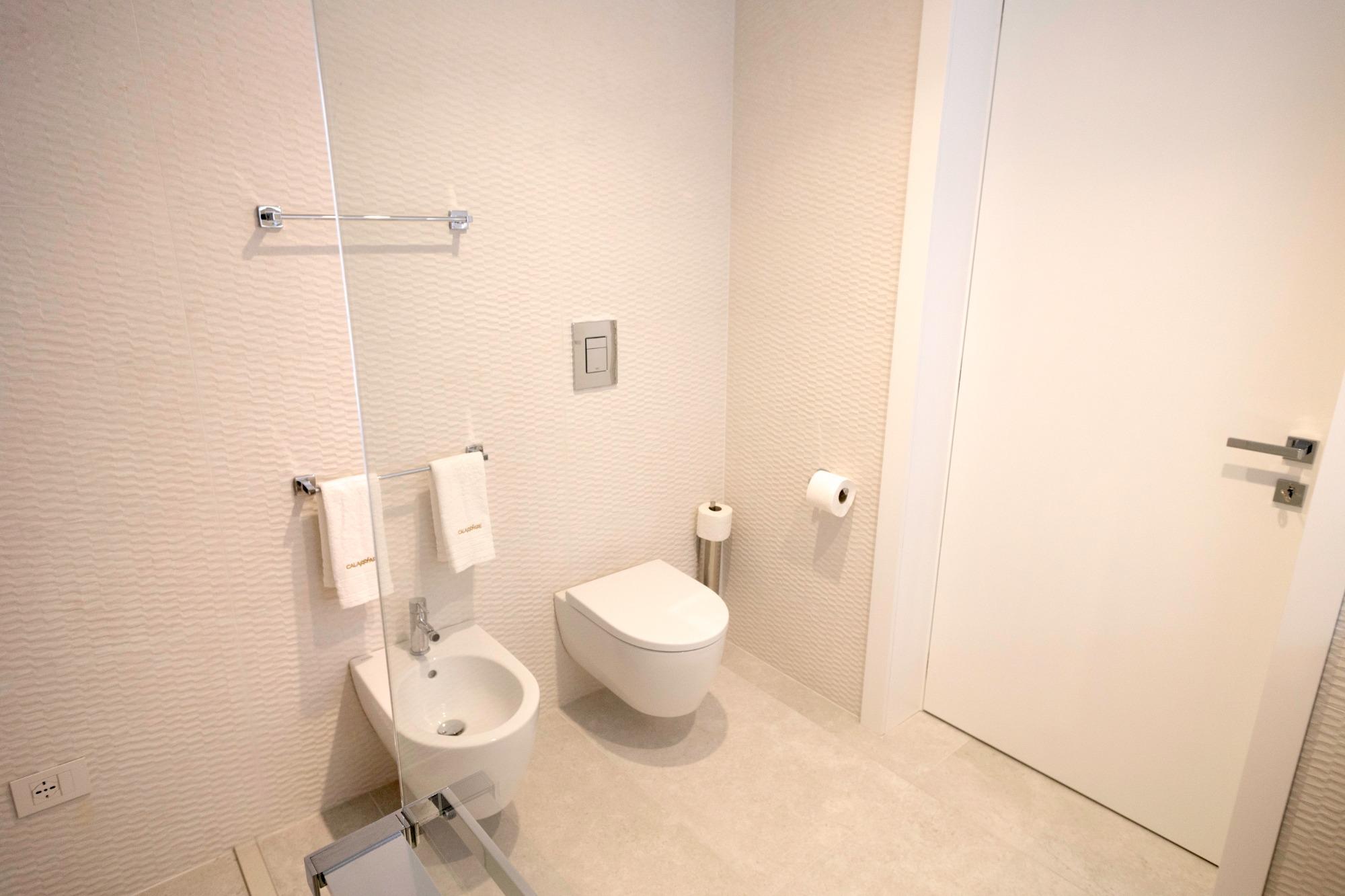 Bagno moderno con doccia a filo pavimento, wc, bidet el lavabo.